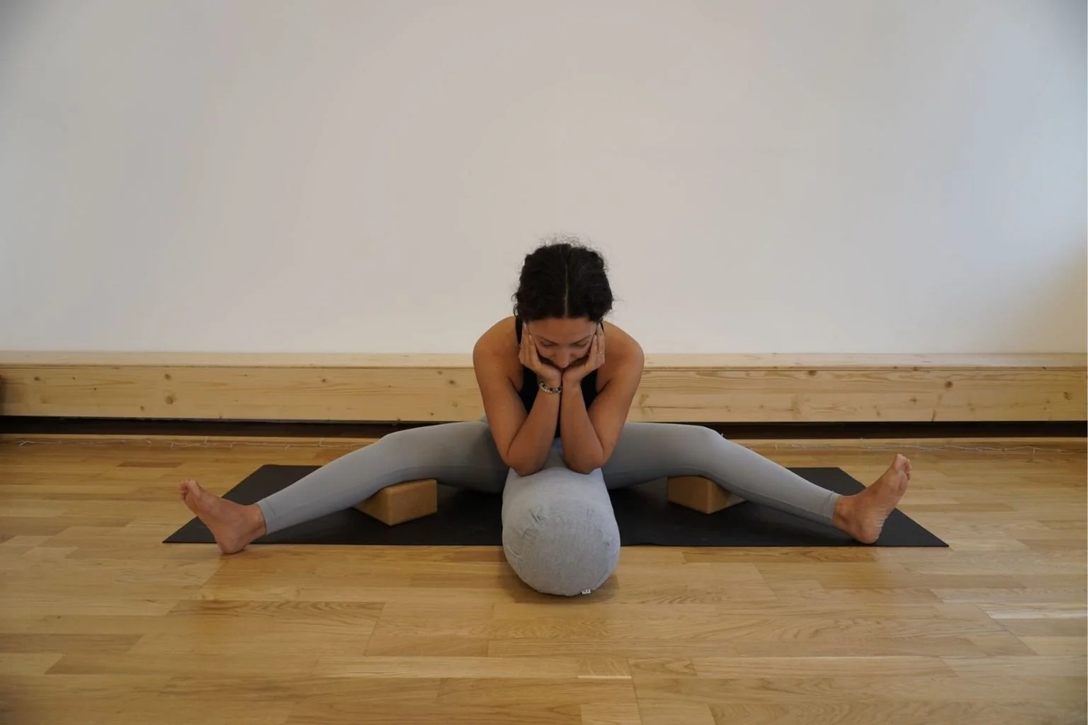 yogalehrerin zeigt eine sitzende vorbeuge