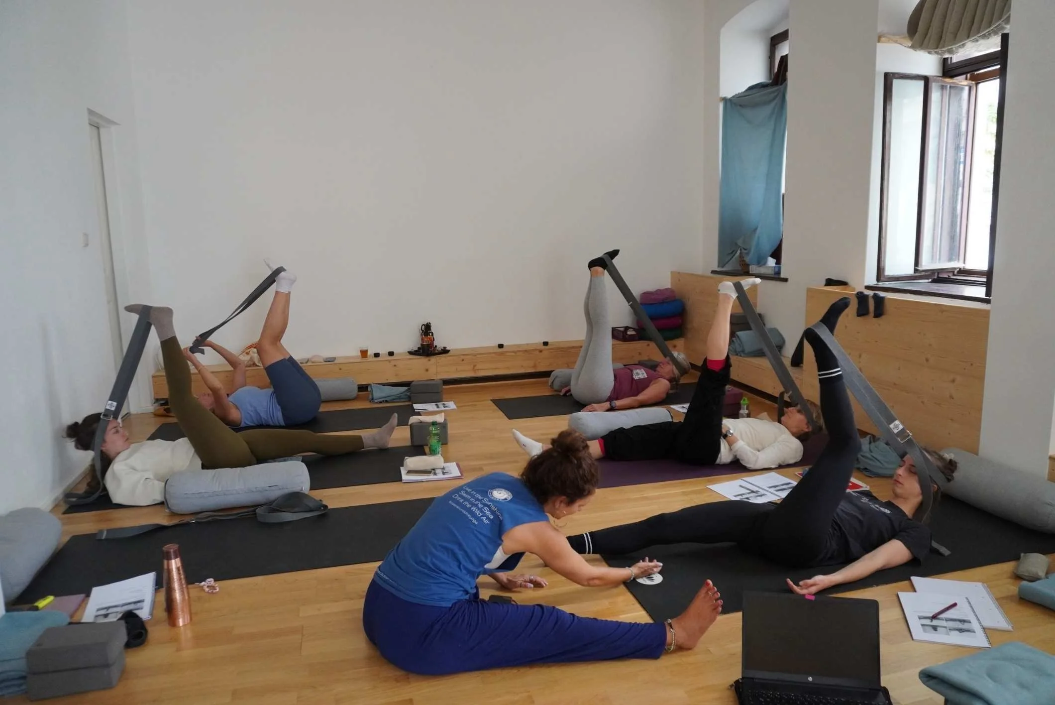 Yin Yoga Lehrerin hilft bei Yin Position mit Gurt