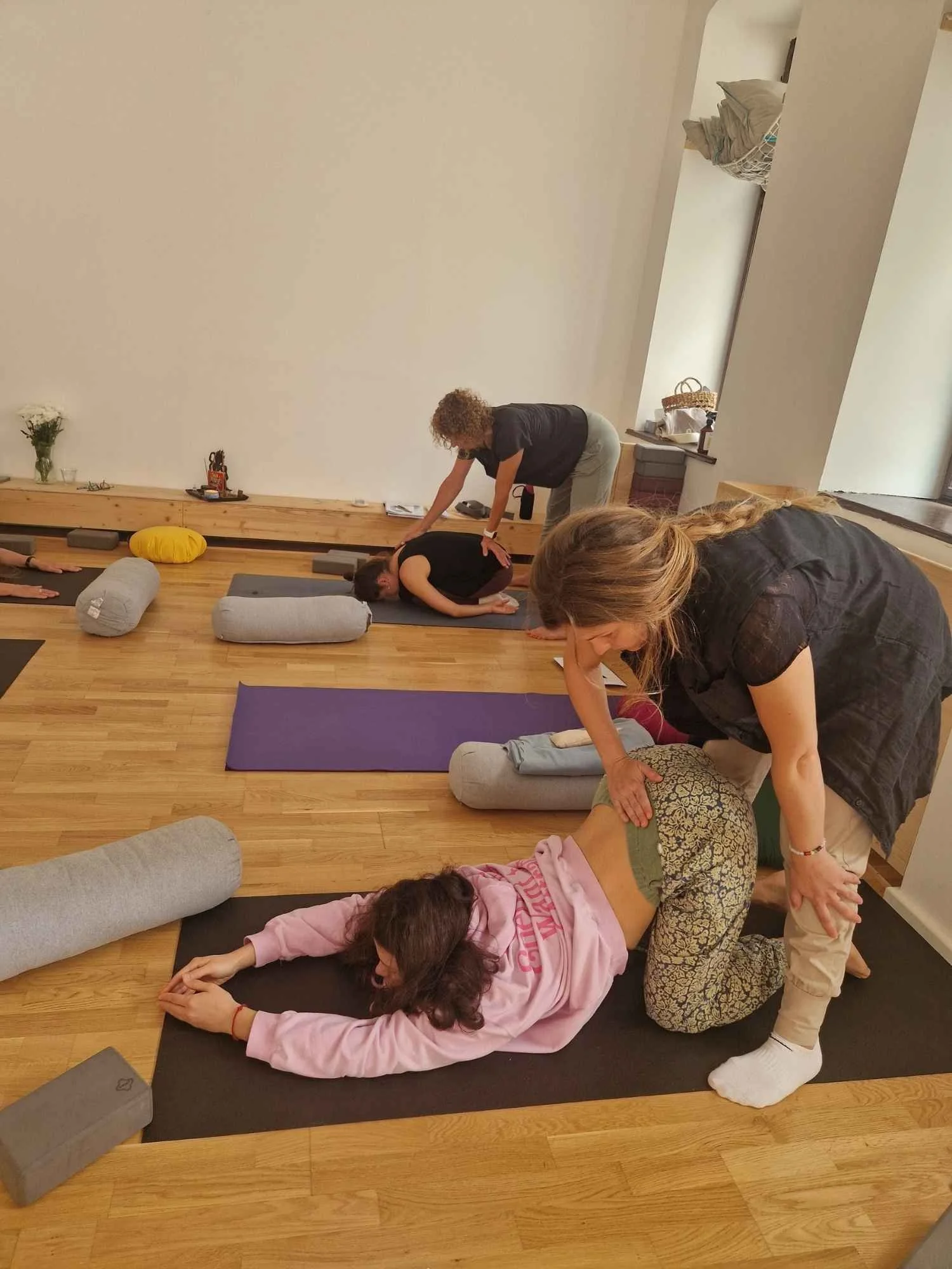 Yin Yoga Assists werden durch Ausbildungsteilnehmerinnen in Zweiergruppen geübt