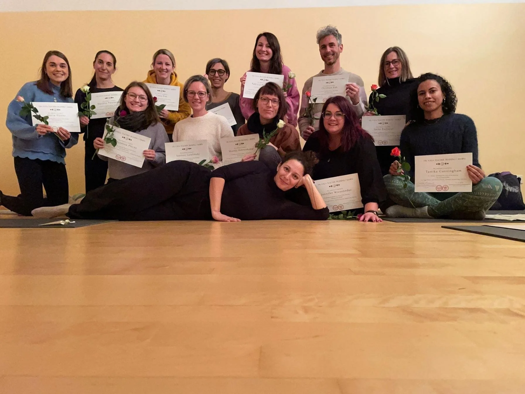 menschen knien auf boden und zeigen ihre zertifikate