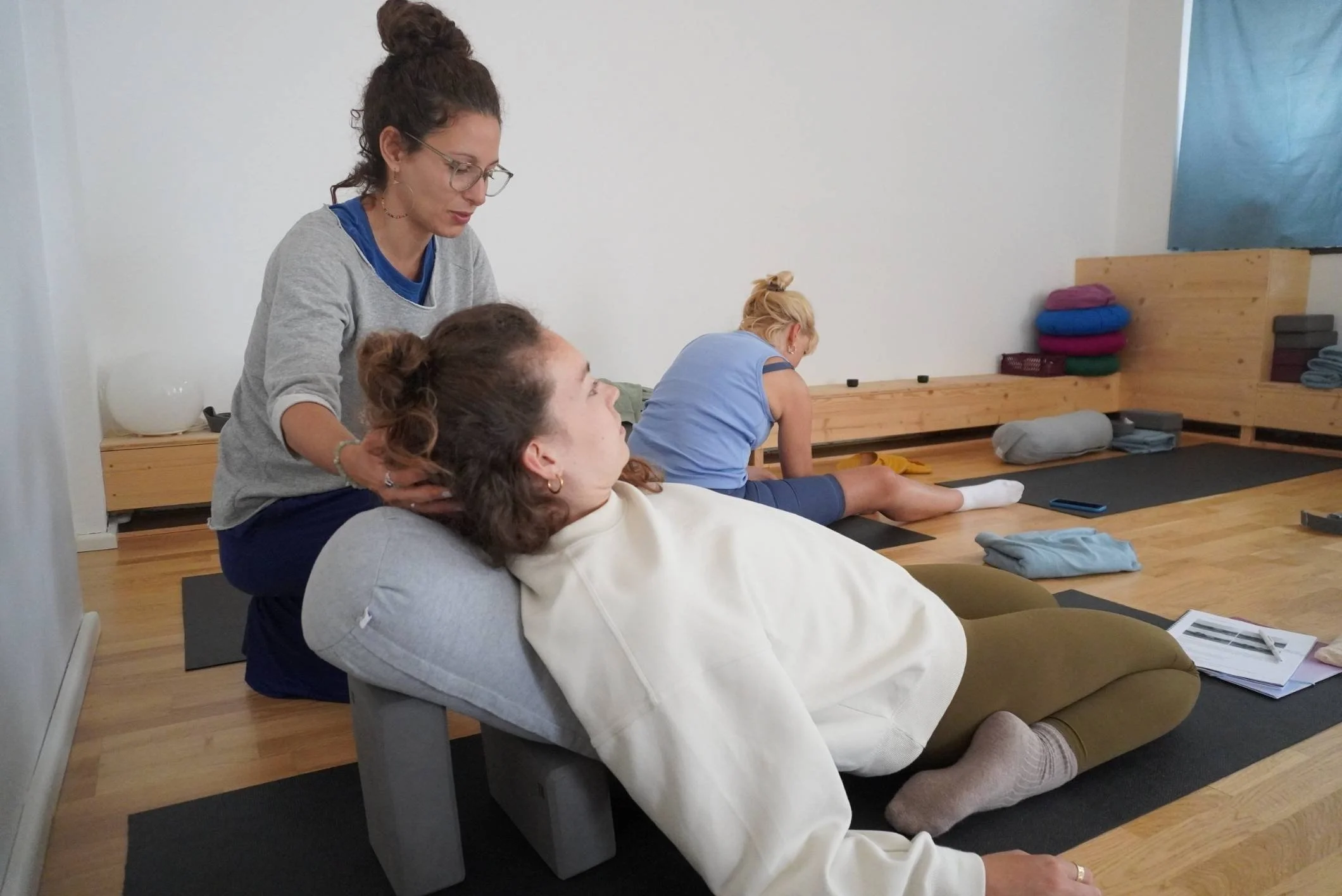 yin yoga position an einer schuelerin erklaert