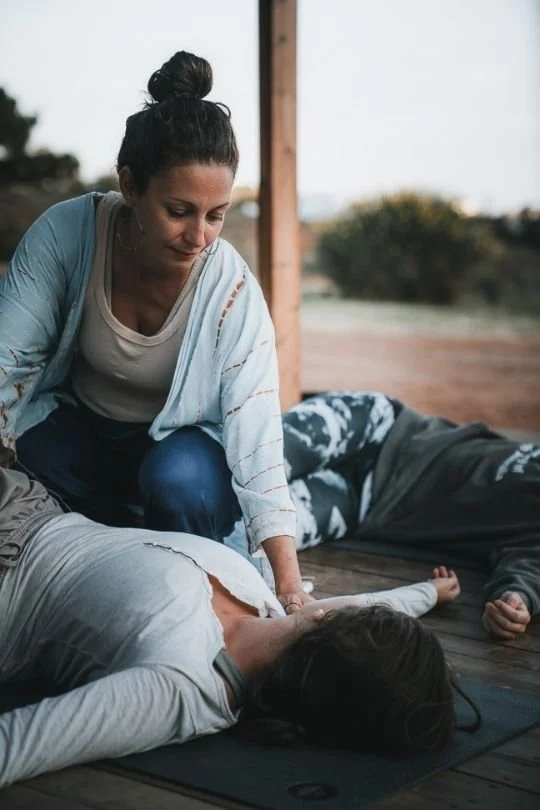 nikoleta macht einen hands-on assist bei schülerin während yin yoga