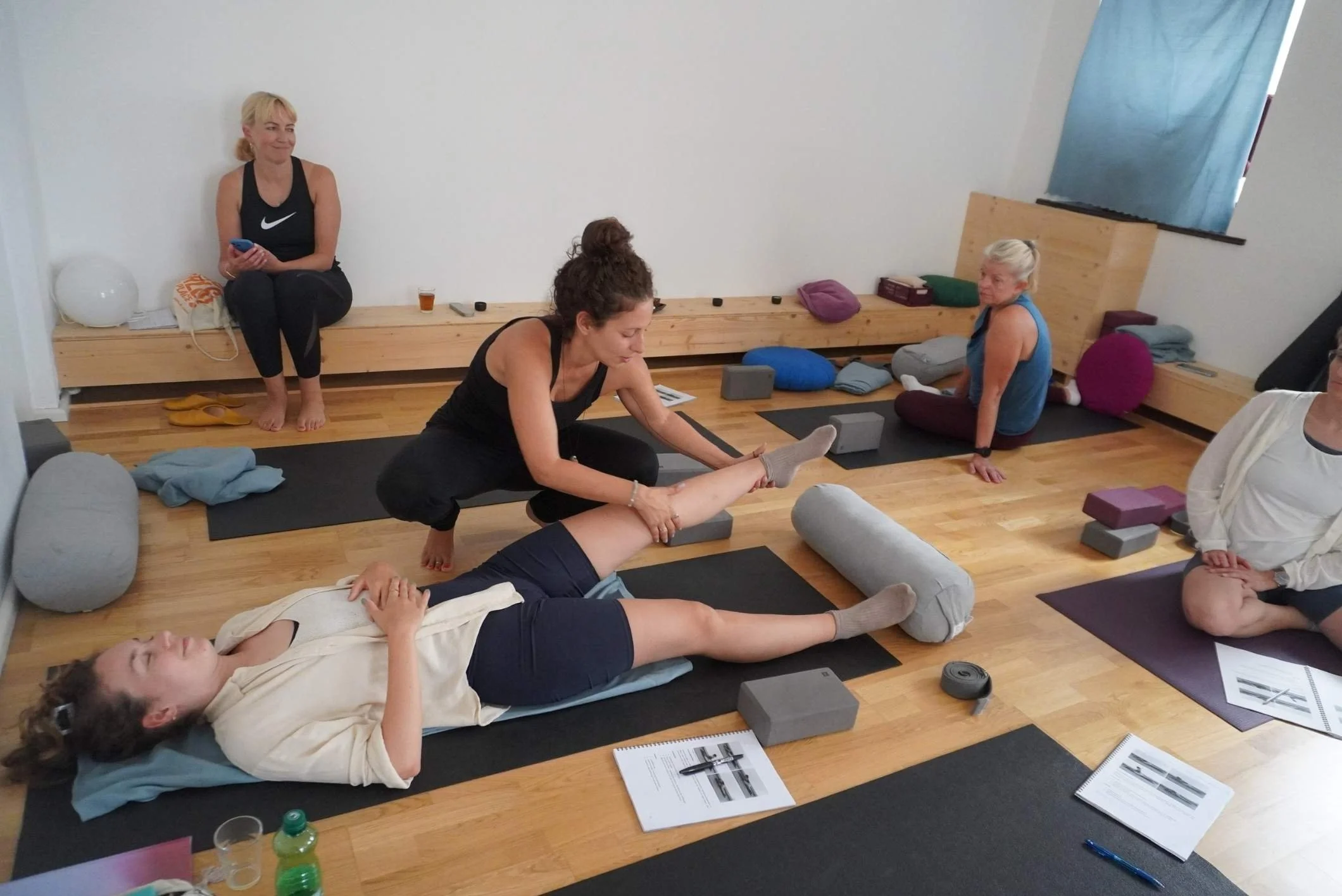 lehrerin erklaert eine yin yoga position entlang der meridiane