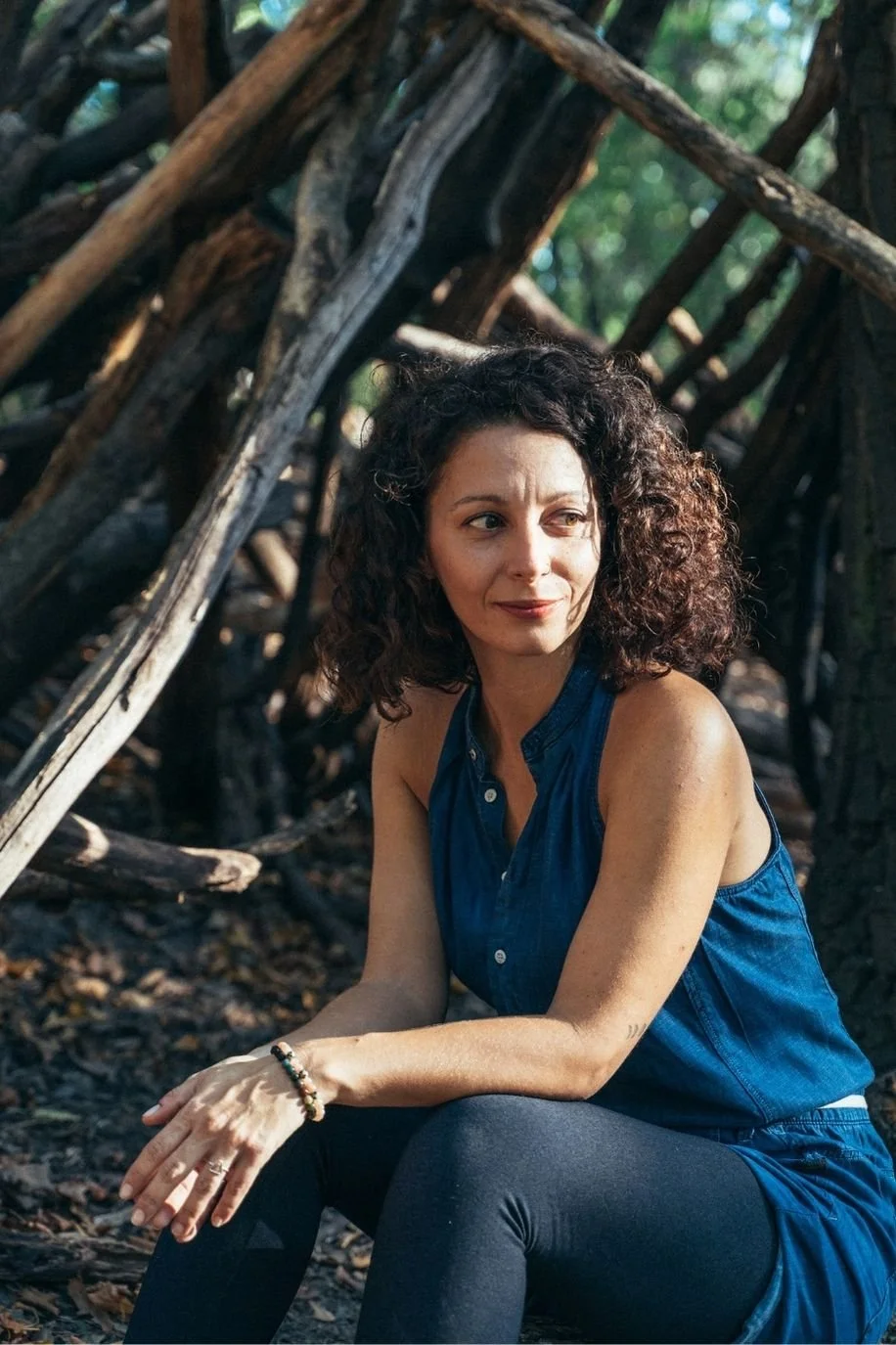 nikoleta nikisianli in wald vor einem baum sitzend