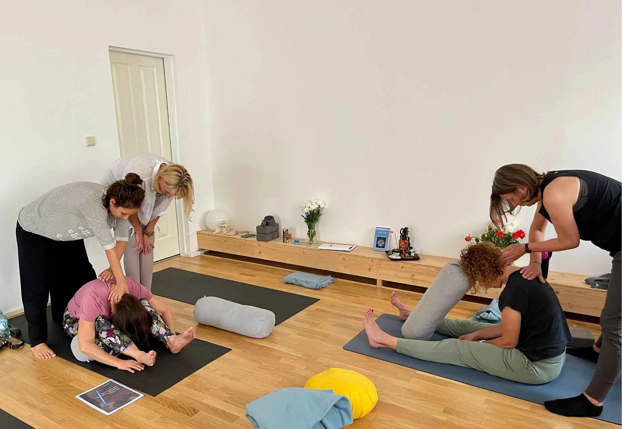 Nikoleta Nikisianli zeigt in der Yin Ausbildung Hands-on Assists während die Teilnehmenden das in Zweiergruppen gleich ausprobieren