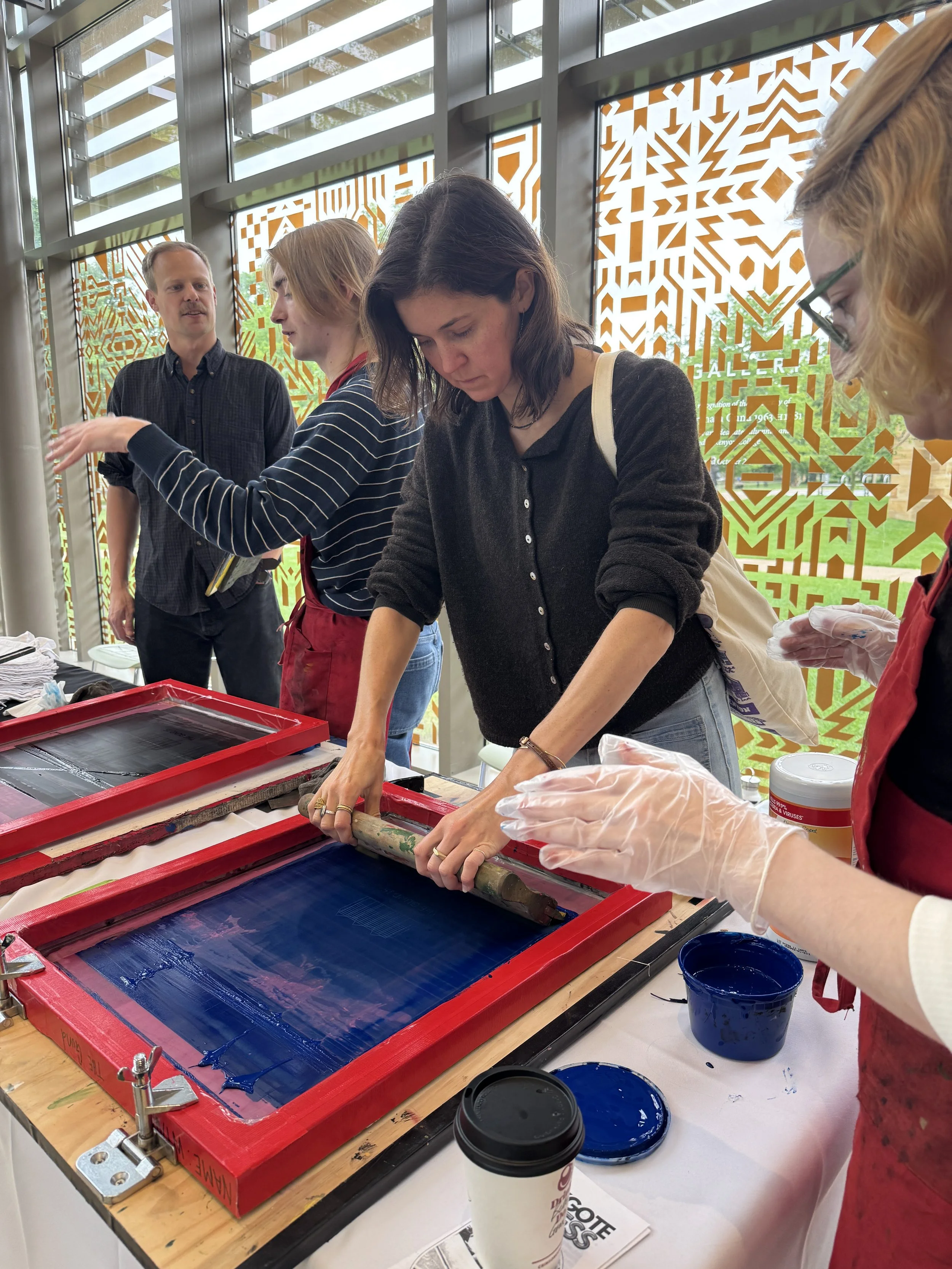 Woman screenprinting with blue ink at Zygote Press off-site event