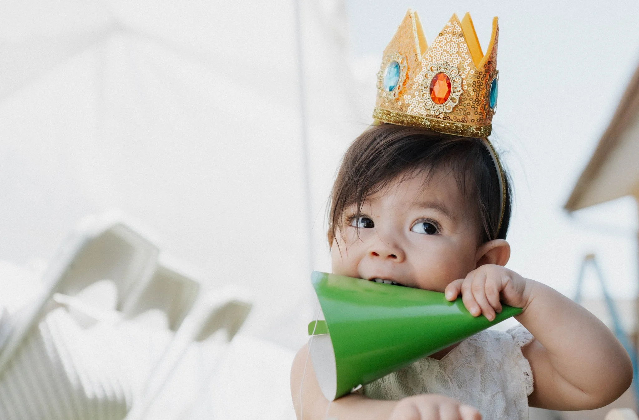 baby girl holding a birthday hat