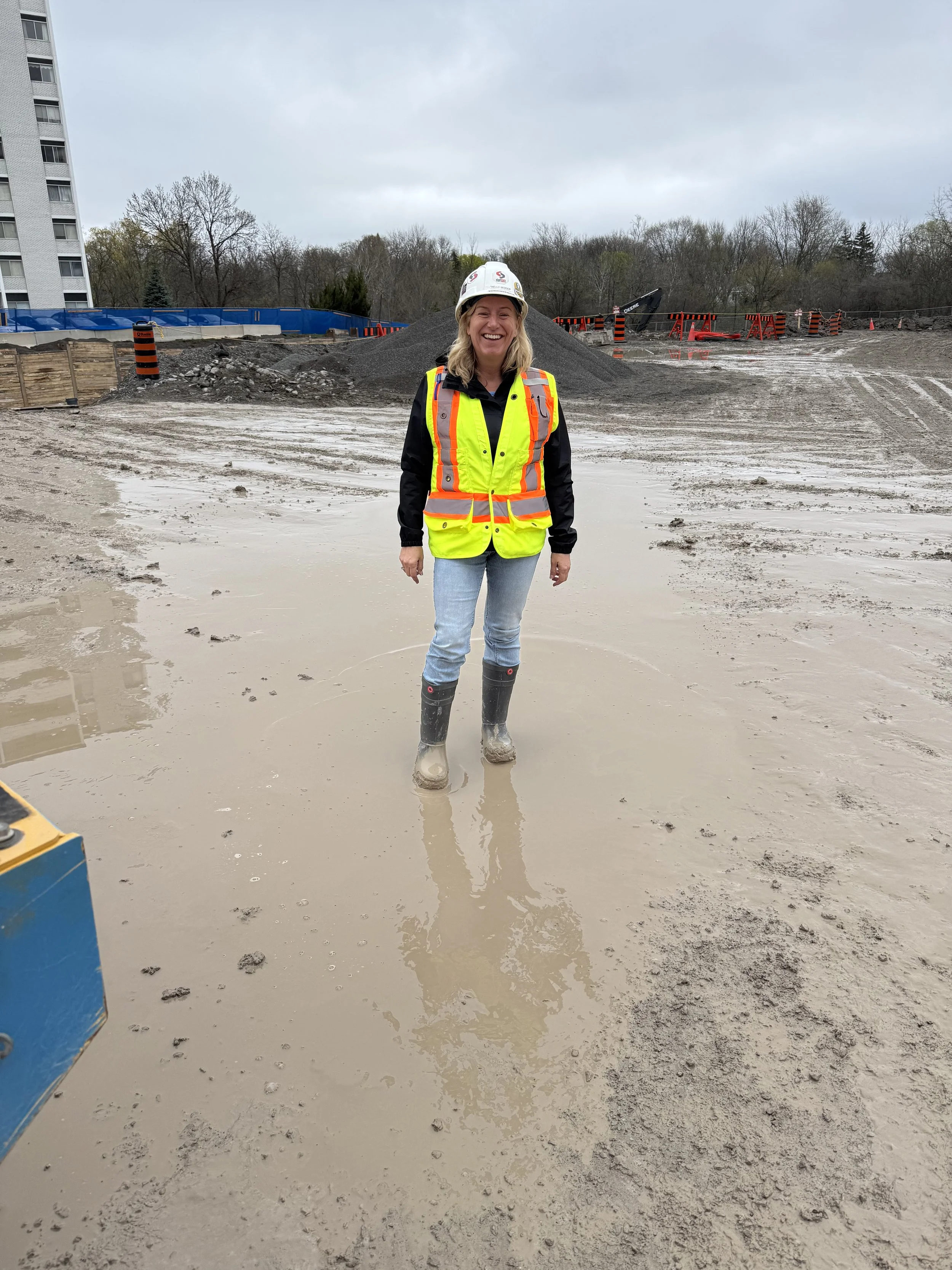 Kelly Widdop wearing high-visibility clothing, work boots and a hard hat on a construction jobsite
