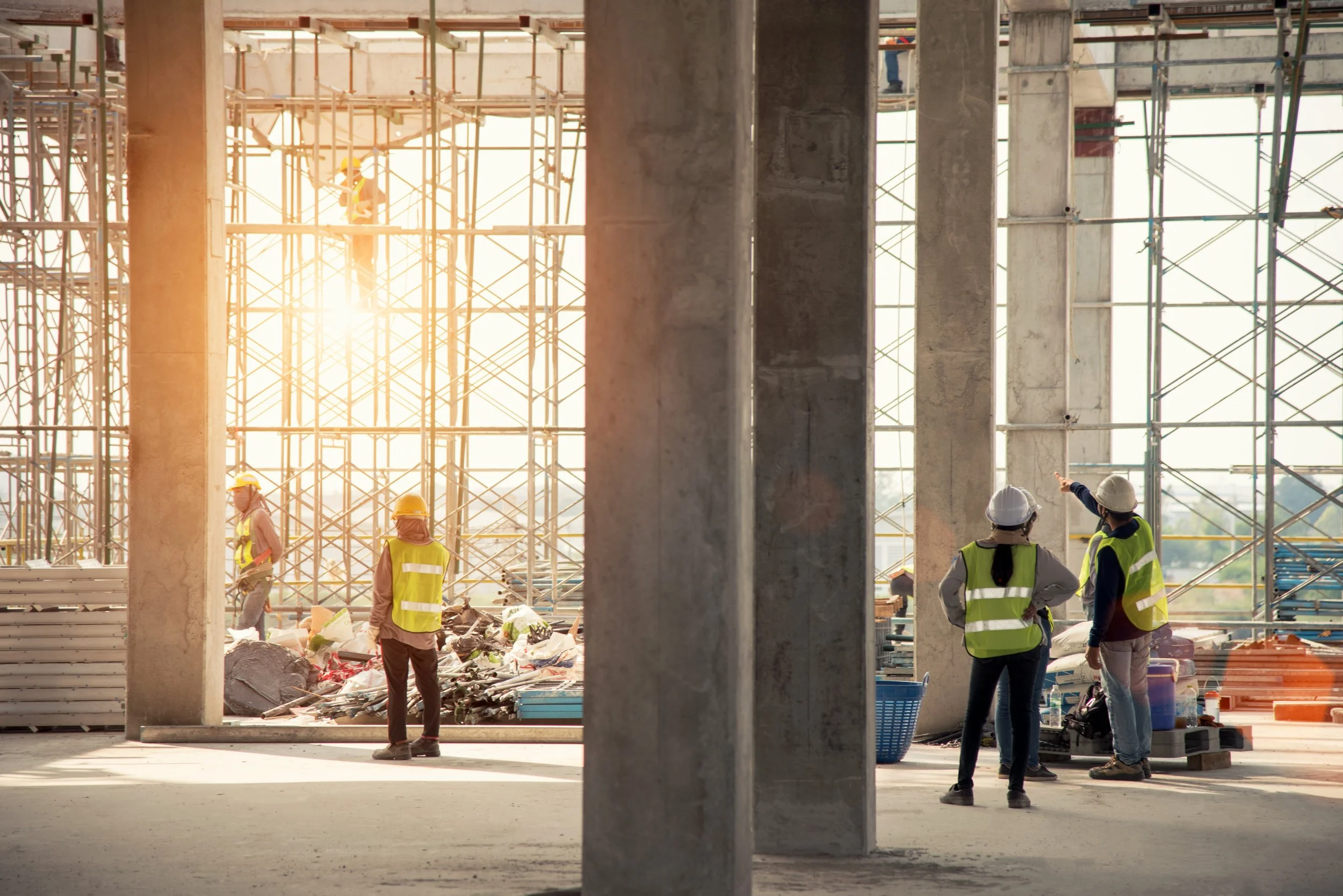 Workers reviewing activity inside a concrete construction site