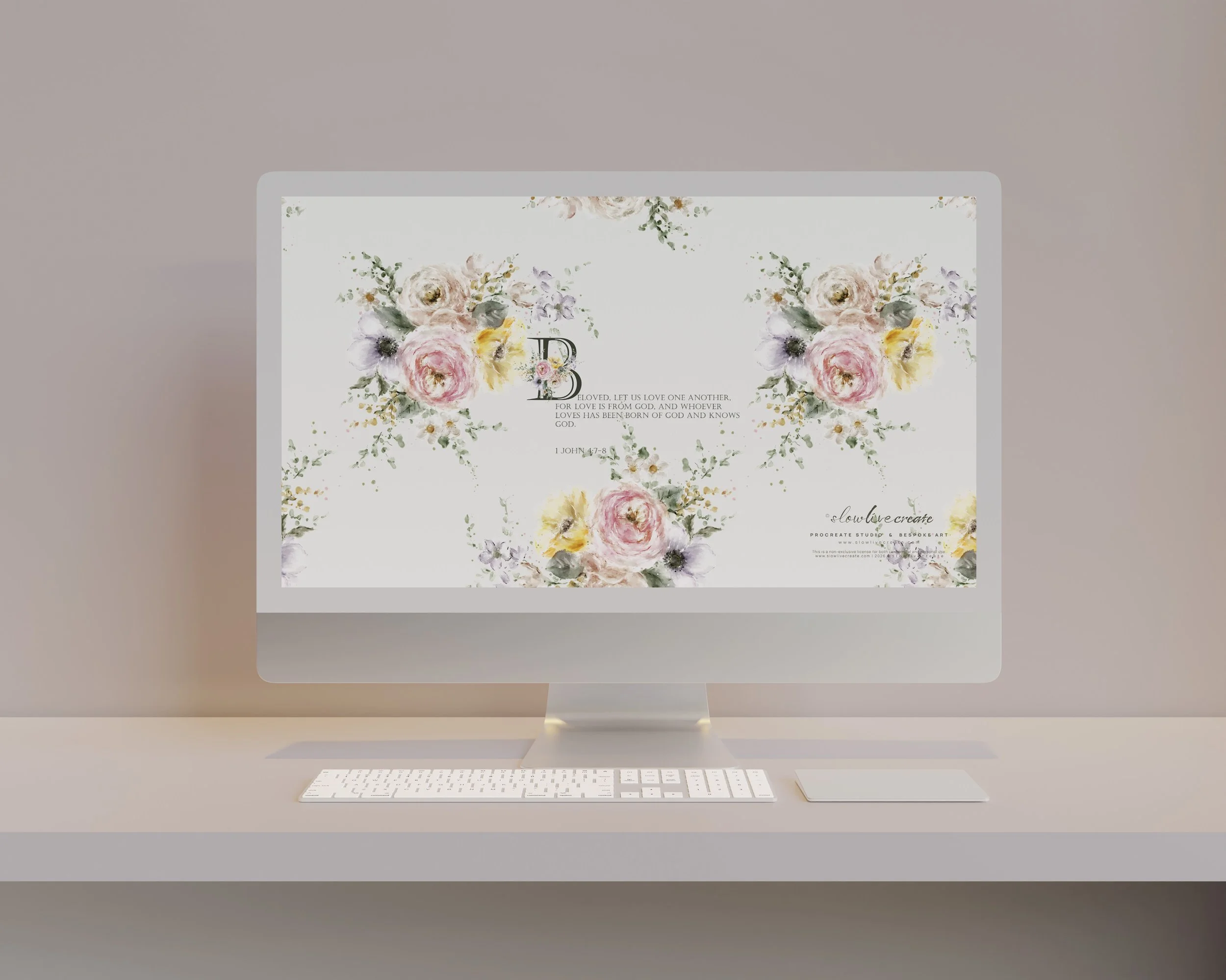 An Apple iMac computer with a floral wallpaper and a Bible verse displayed on the screen, accompanied by a wireless keyboard and mouse, set on a desk with a neutral background.