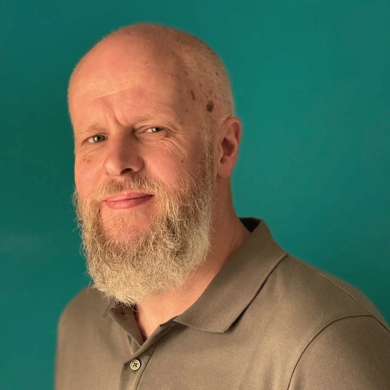 A man with a beard smiling at the camera.