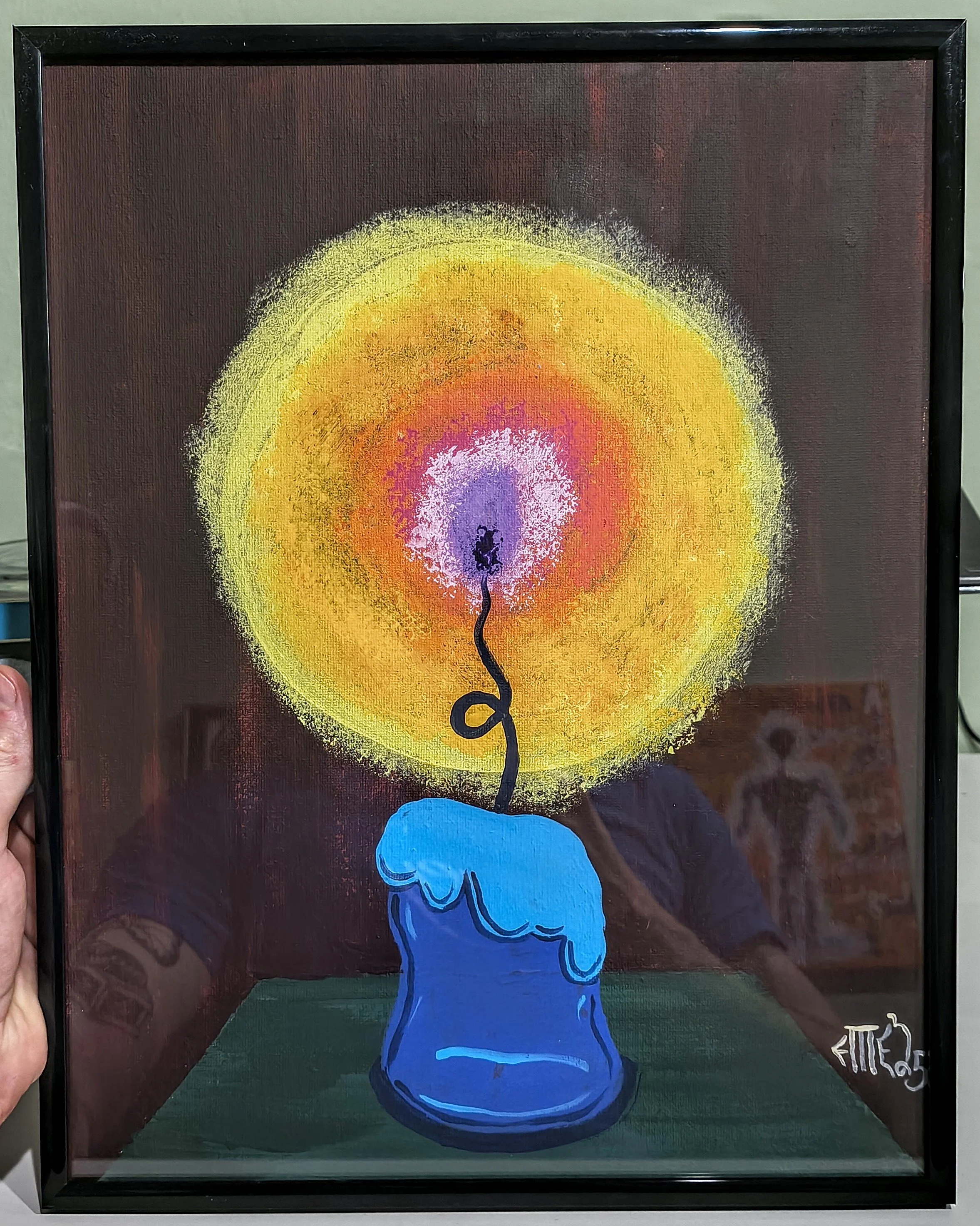A painting of a blue hand holding a lit fuse connected to a spherical explosion of bright colors including yellow, orange, pink, and purple, on a dark background.