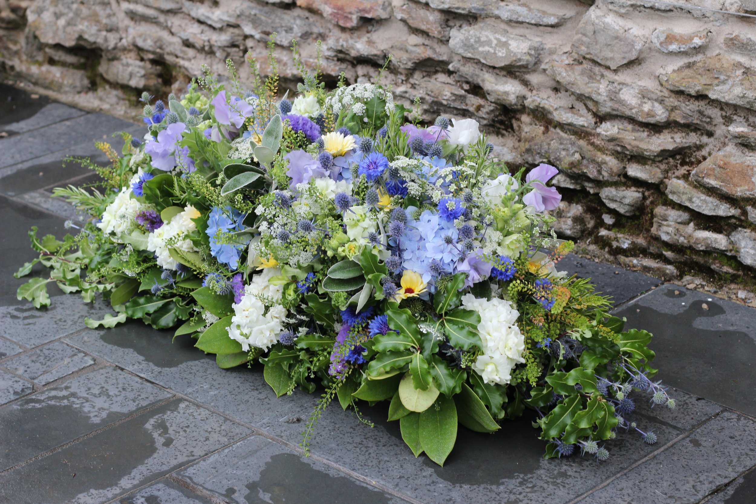 Funeral spray with blue thistle, cornflower and white hydrangea from Blue Hill Flora