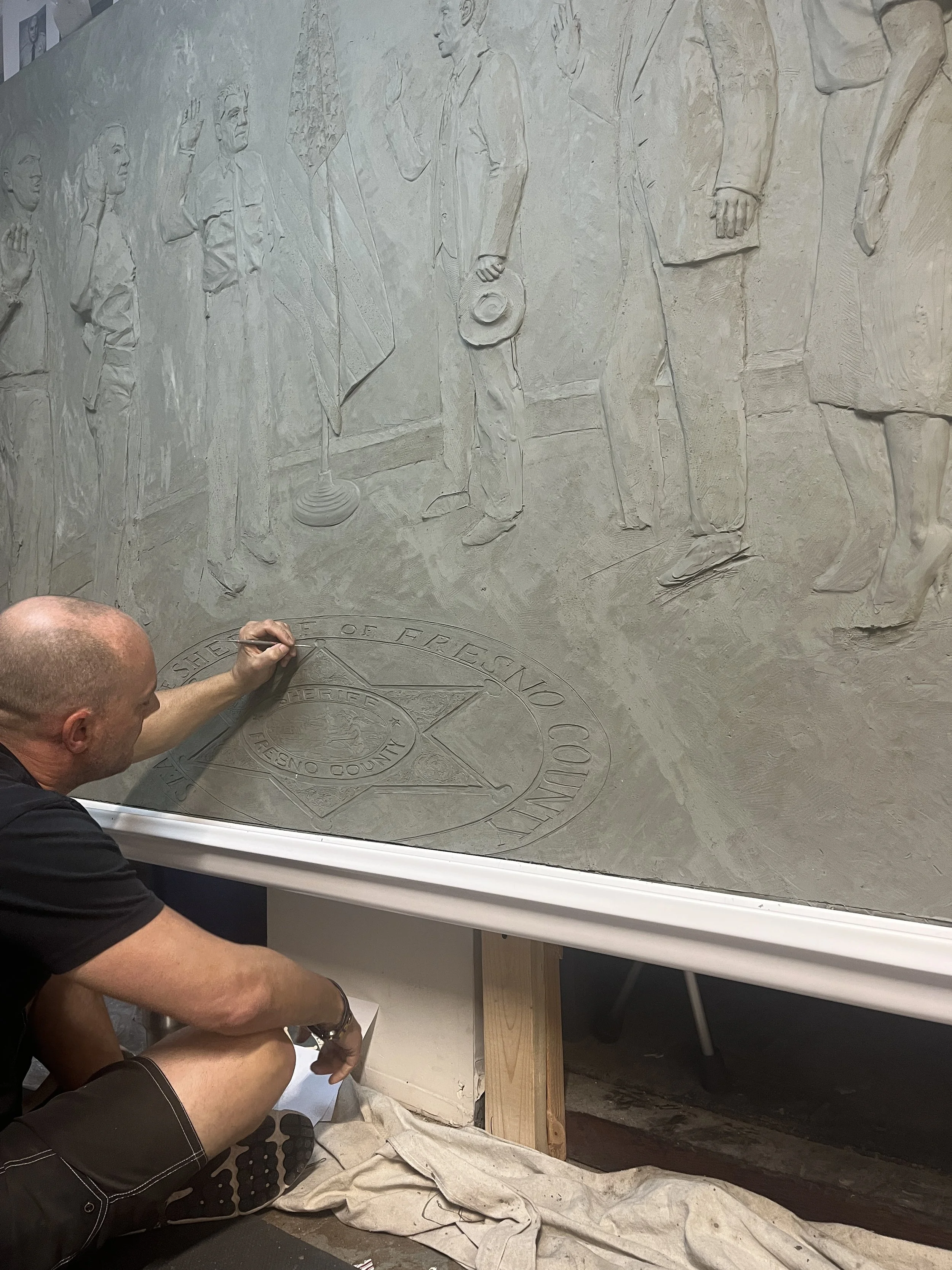 John Sumner sculpting the Seal of Fresno Sheriff's Station