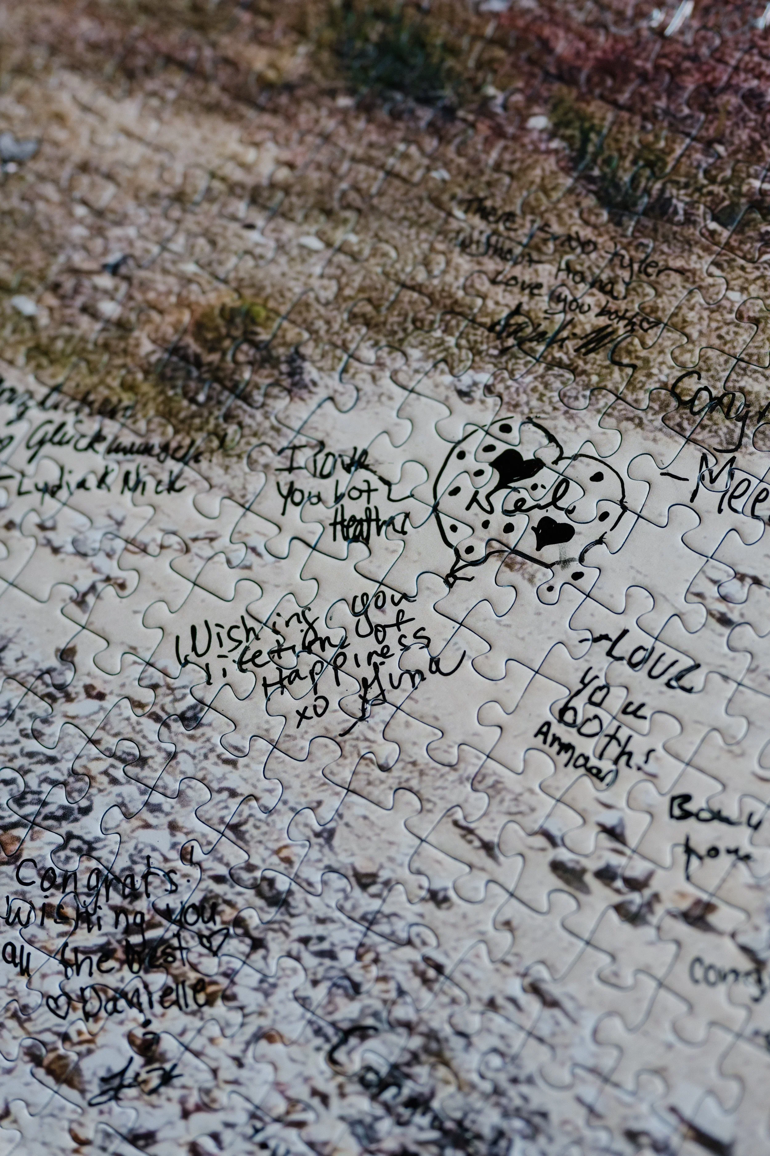 A jigsaw puzzle featuring handwritten messages as a wedding guest book, including a drawing of a Dalmatian dog, laid out on a surface.