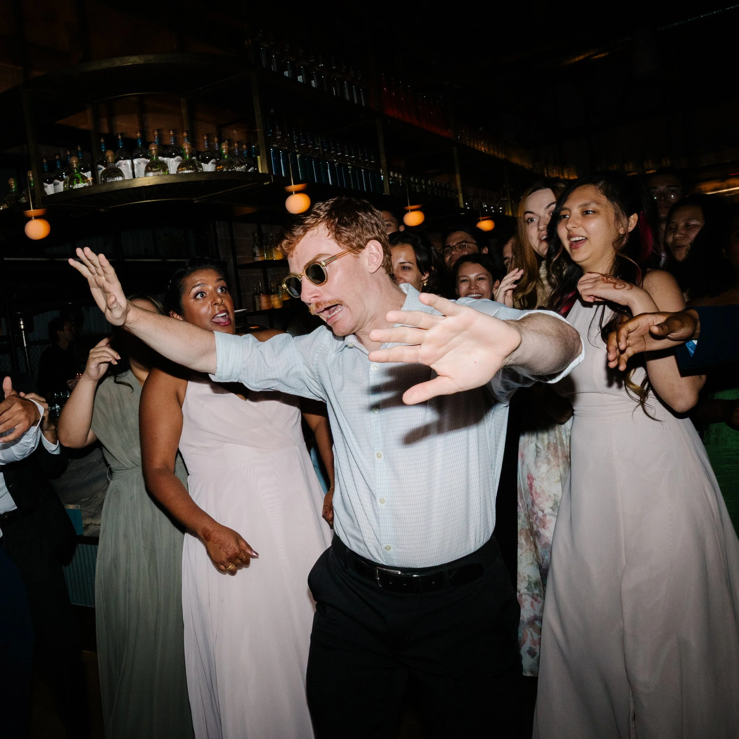 A group of people dancing and having fun at a wedding reception.