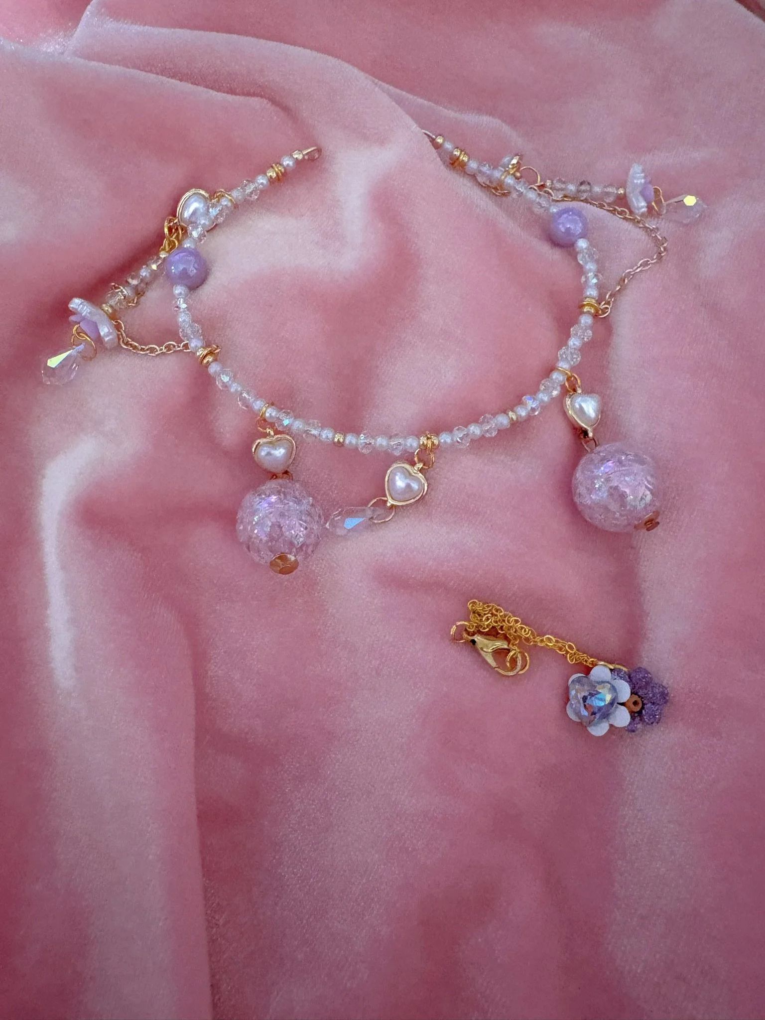 $45.00. 

Crystal and pearl crown with dangling lavender baubles and crystals. Includes matching crystal heart and flower necklace. 

Adjustable, best fits dolls with size 7/8 through size 9/10 heads.