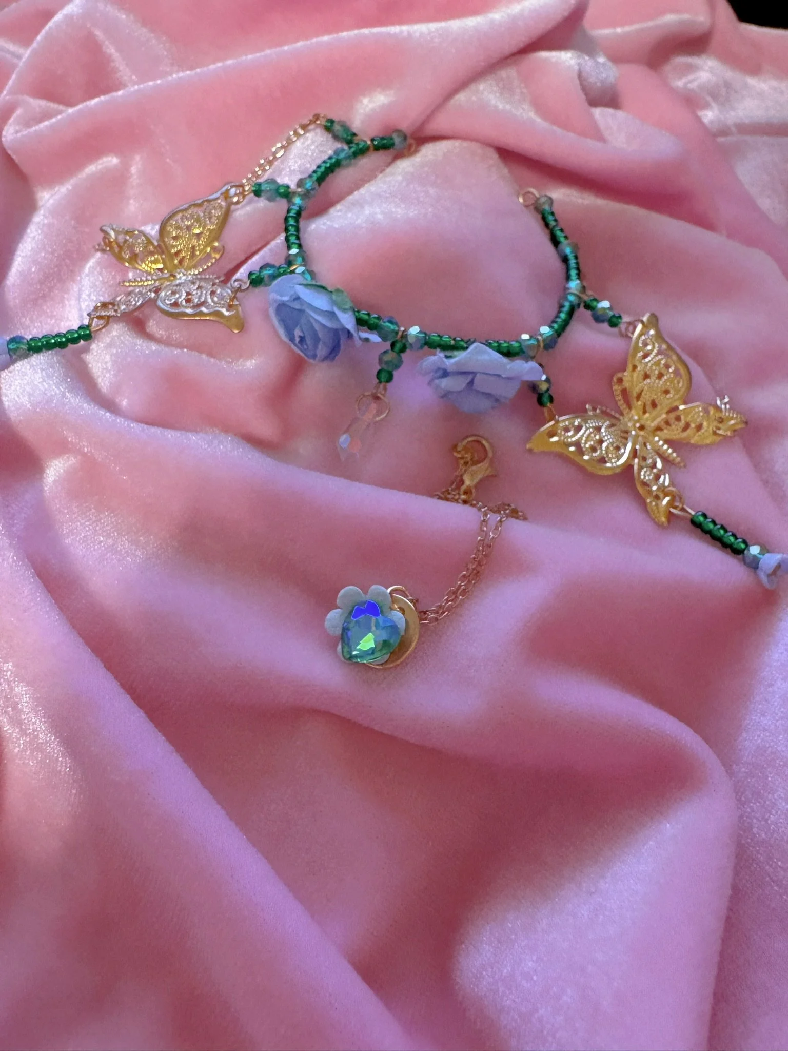 $25.00. 

Green bead and baby blue rose crown with gold butterflies. Includes matching crystal heart and flower necklace. 

Adjustable, best fits dolls with size 6/7 through size 8/9 heads.