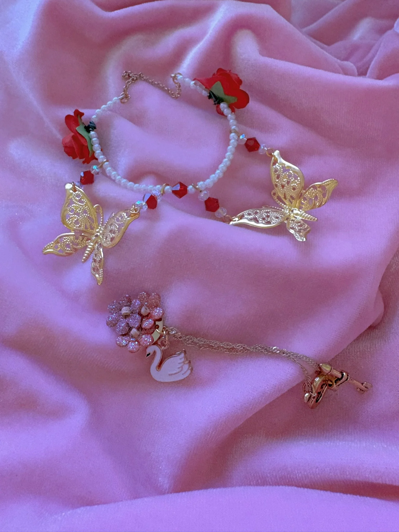 $15.00. 

Reverse design tiara (flowers go in the back). Front is a gold chain, back has red roses, gold butterflies, and crystal and pearl beads. Includes matching crystal heart and flower necklace. 

Adjustable, best fits dolls with size 4/5 throug