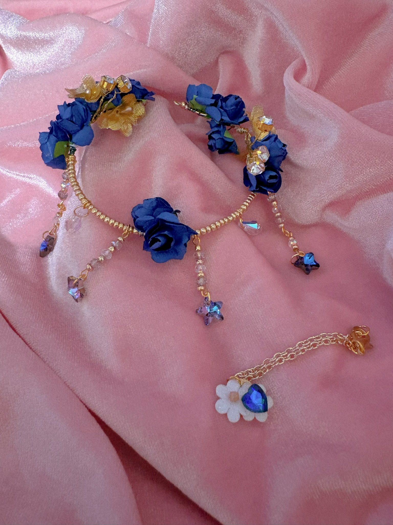 $35.00. 

Blue rose crown with dangling crystal stars. Includes matching crystal and flower necklace. 

Adjustable, best fits size 7/8 through size 9/10 heads.