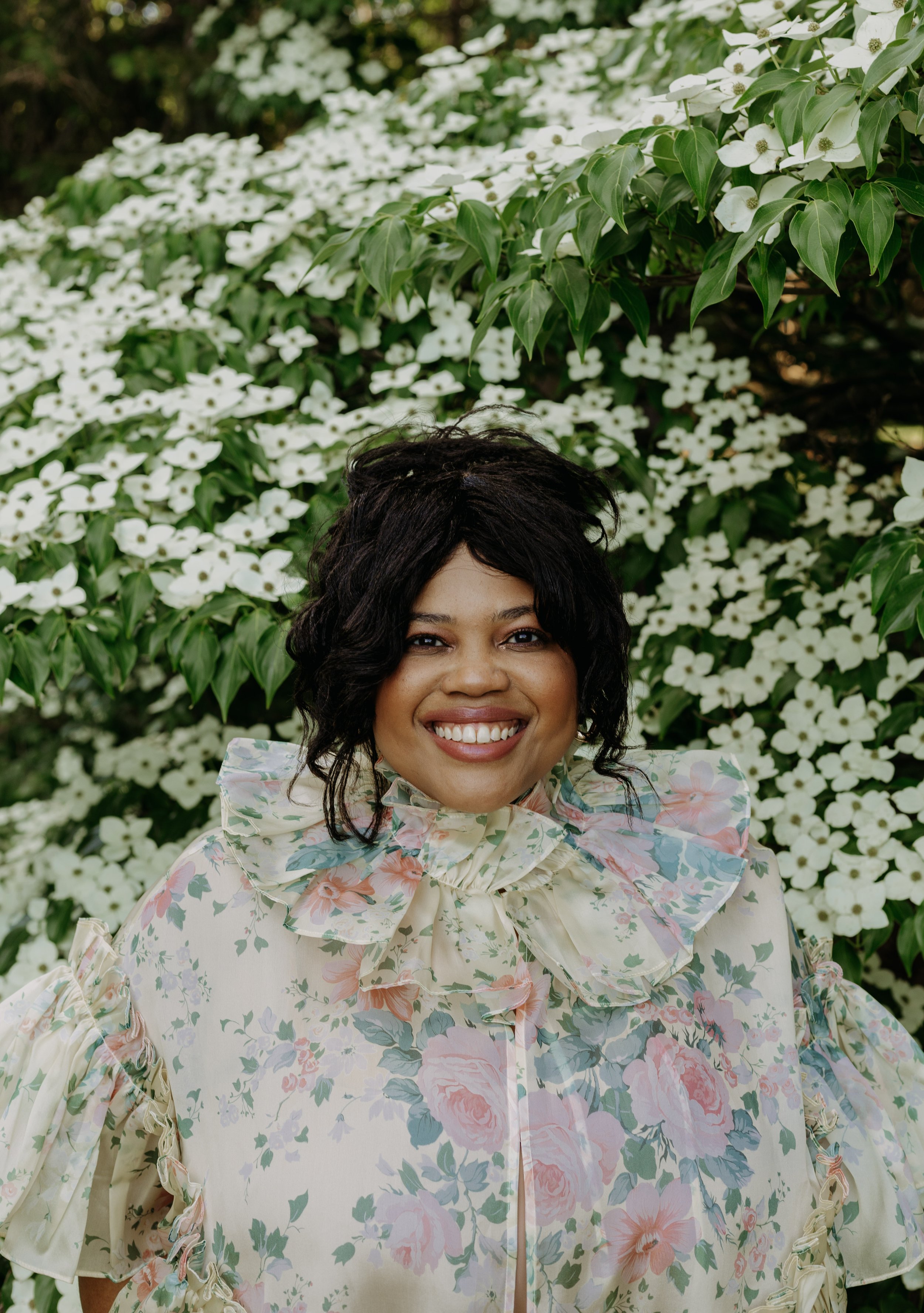 Headshot of Misha against a floral background