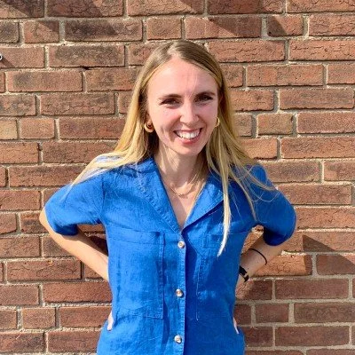 Headshot of Olivia against a brick wall