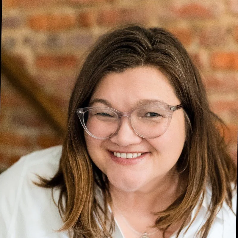 Headshot of Jen against a brick wall