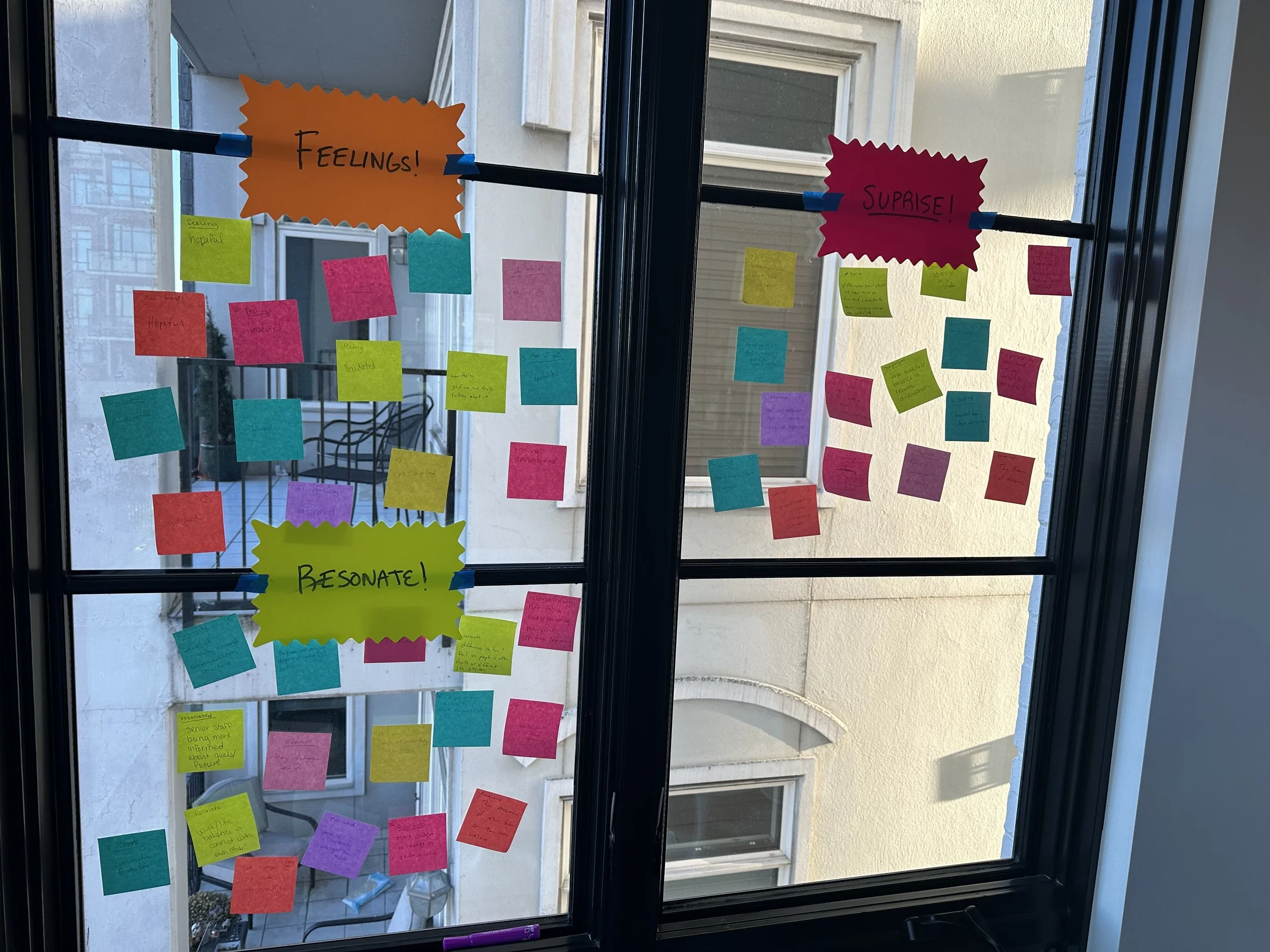 Post-it's from a debrief exercise on a window.