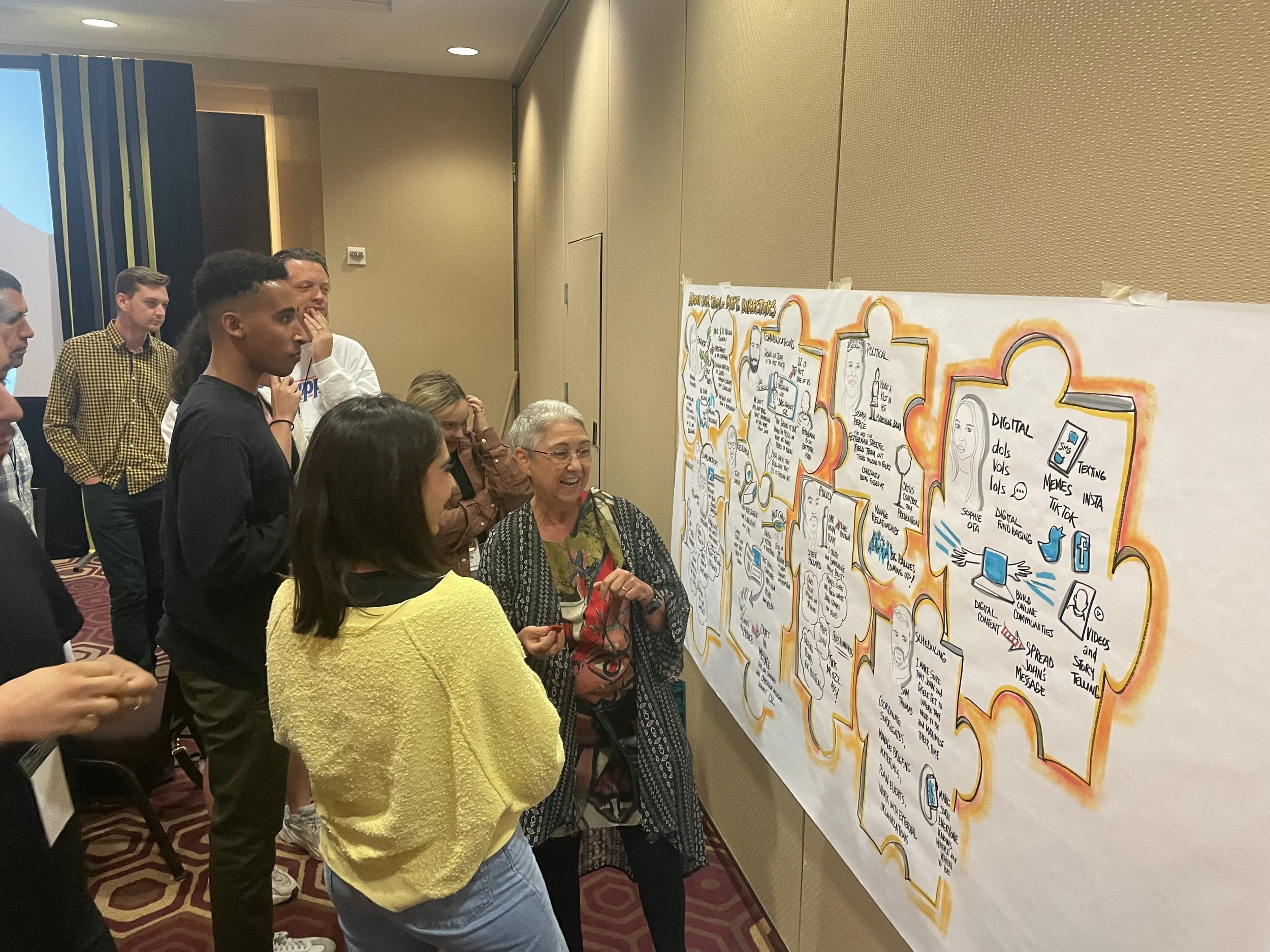 Graphic facilitator Leah Silverman shows a group her illustration of the team's conversation at an all-staff retreat.