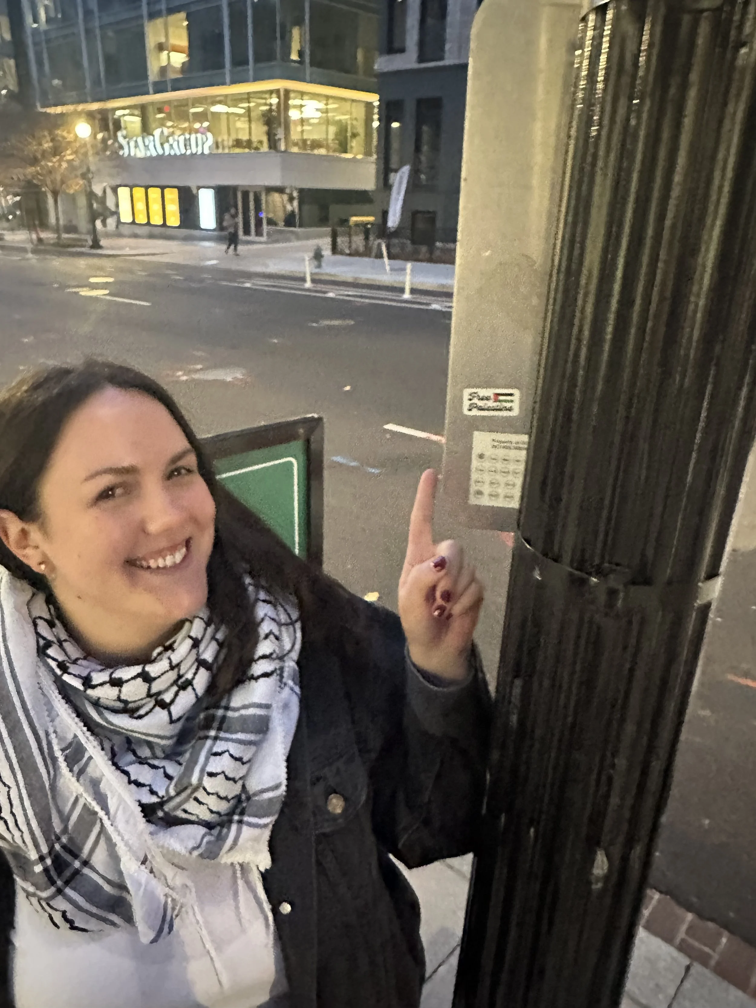 Jules points happily to a Free Palestine sticker on a lamp post in Washington DC