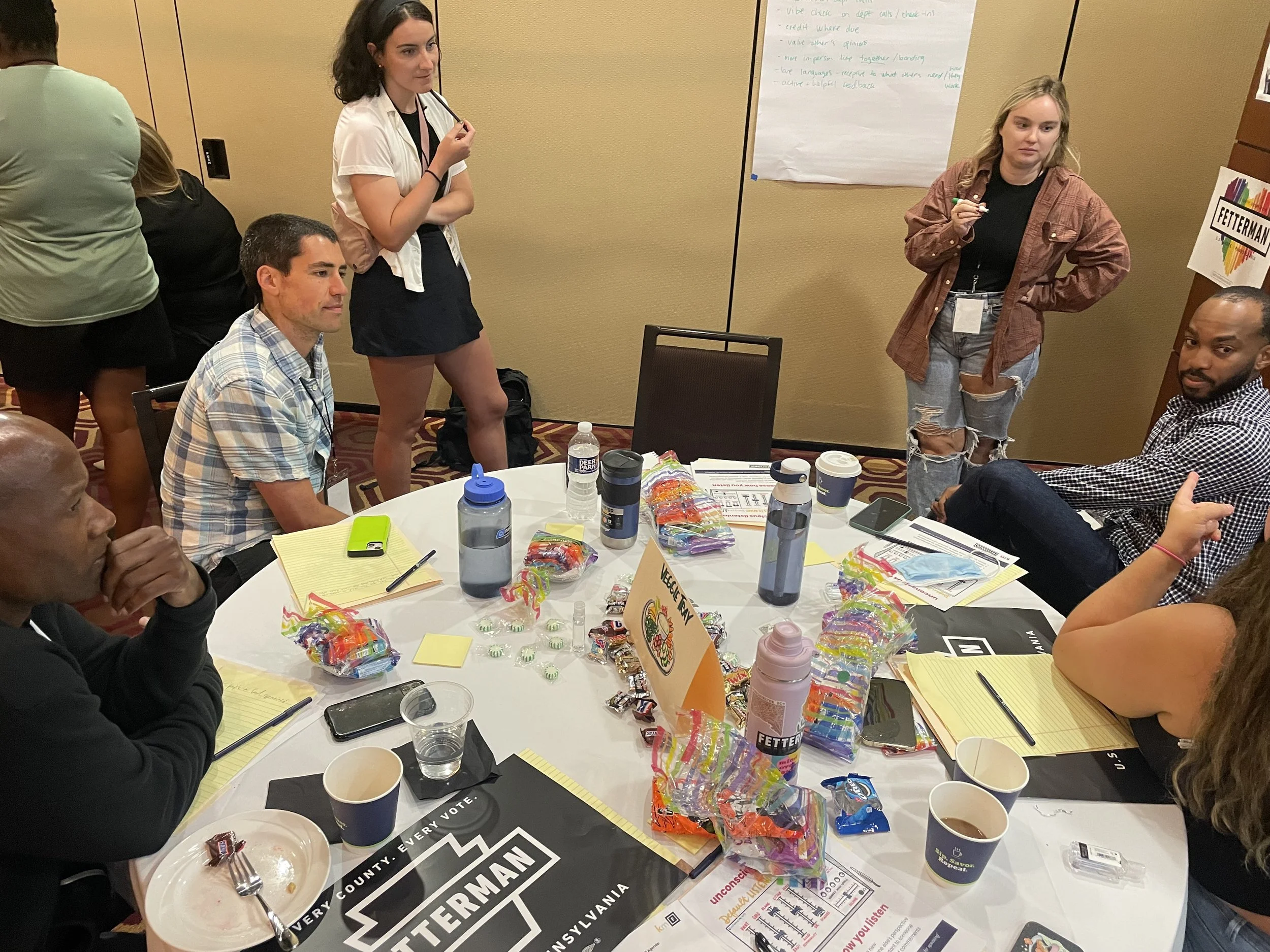 Participants gather around a circular table for a thoughtful discussion.