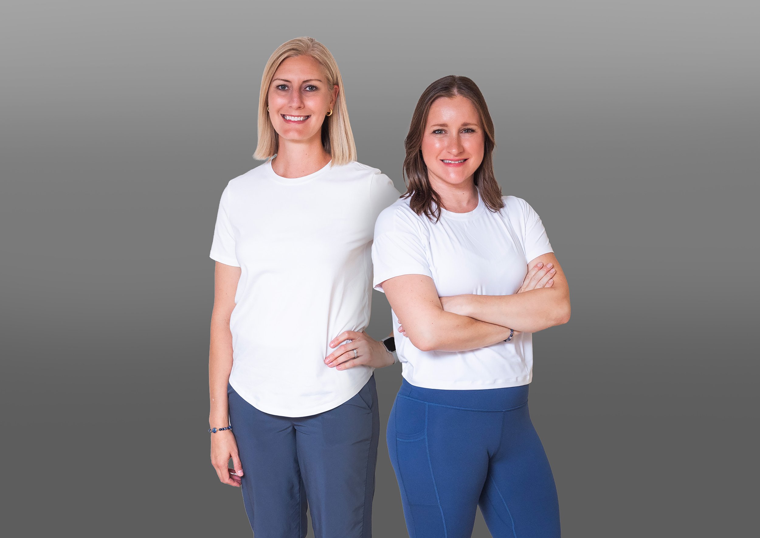 Two women stand wearing athletic apparel.