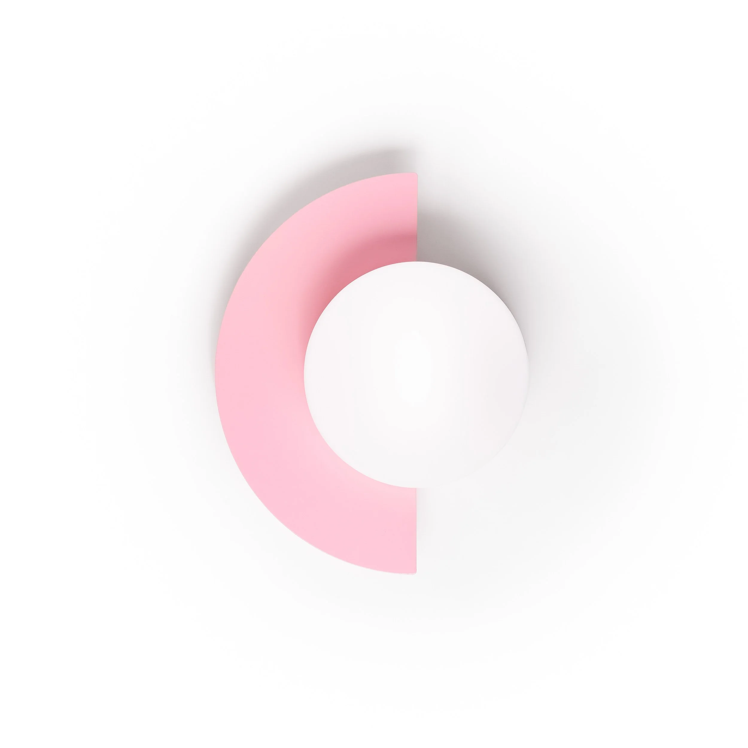 Close-up of pink and white paper or plastic circular shapes on a white background.