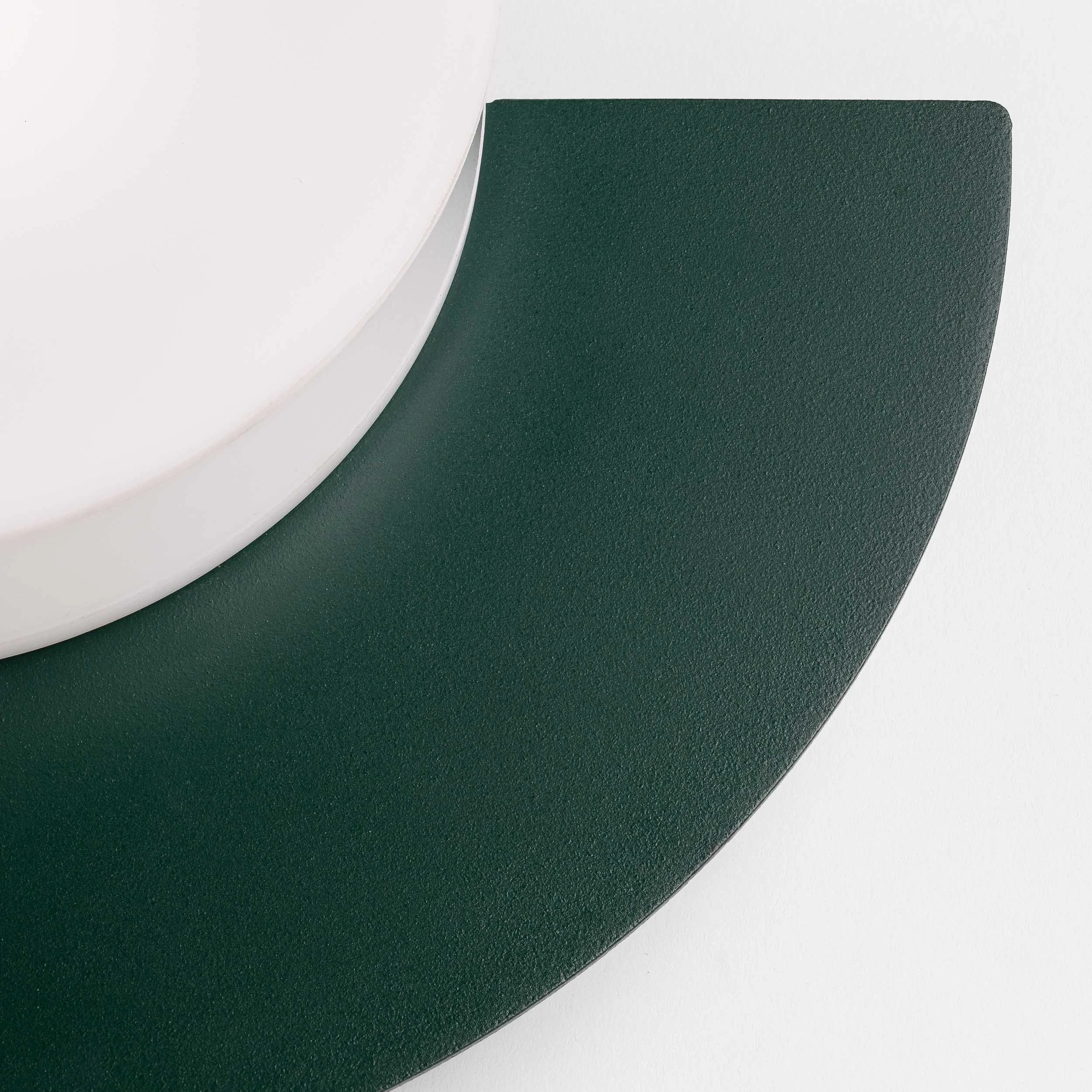 Close-up image of three overlapping sheets of paper in white and dark green colors, with a focus on the edges and textures.