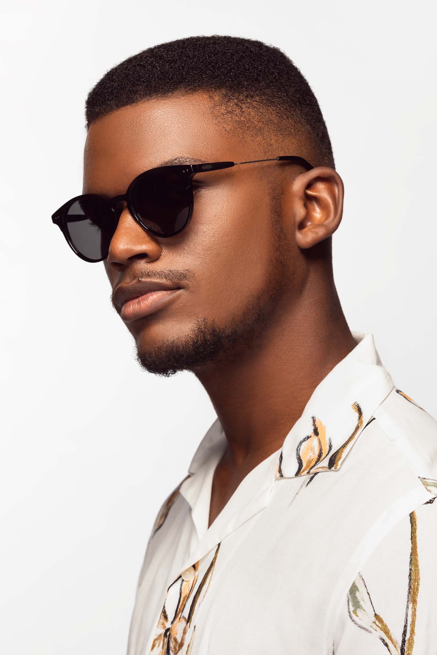 An African man in sunglasses and a white shirt