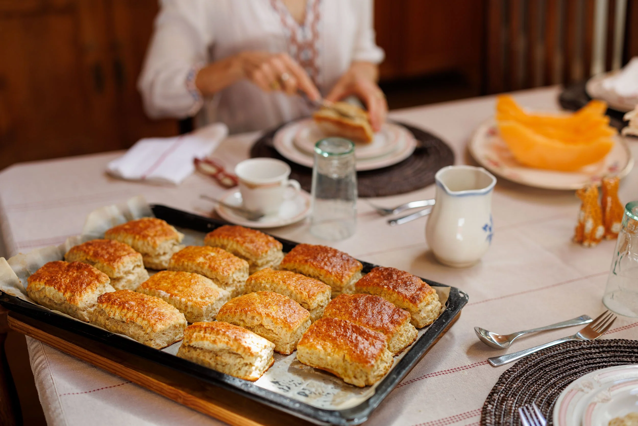 Tray of baked square bread slices on a table set for breakfast.