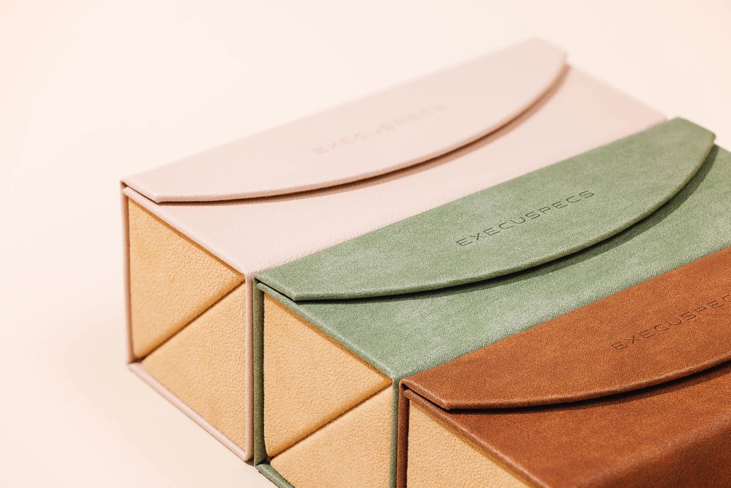 Close-up of color swatches with curved edges, labeled 'EXCEDECS', arranged in a pyramid shape, displaying pastel green, pink, beige, and peach colors.