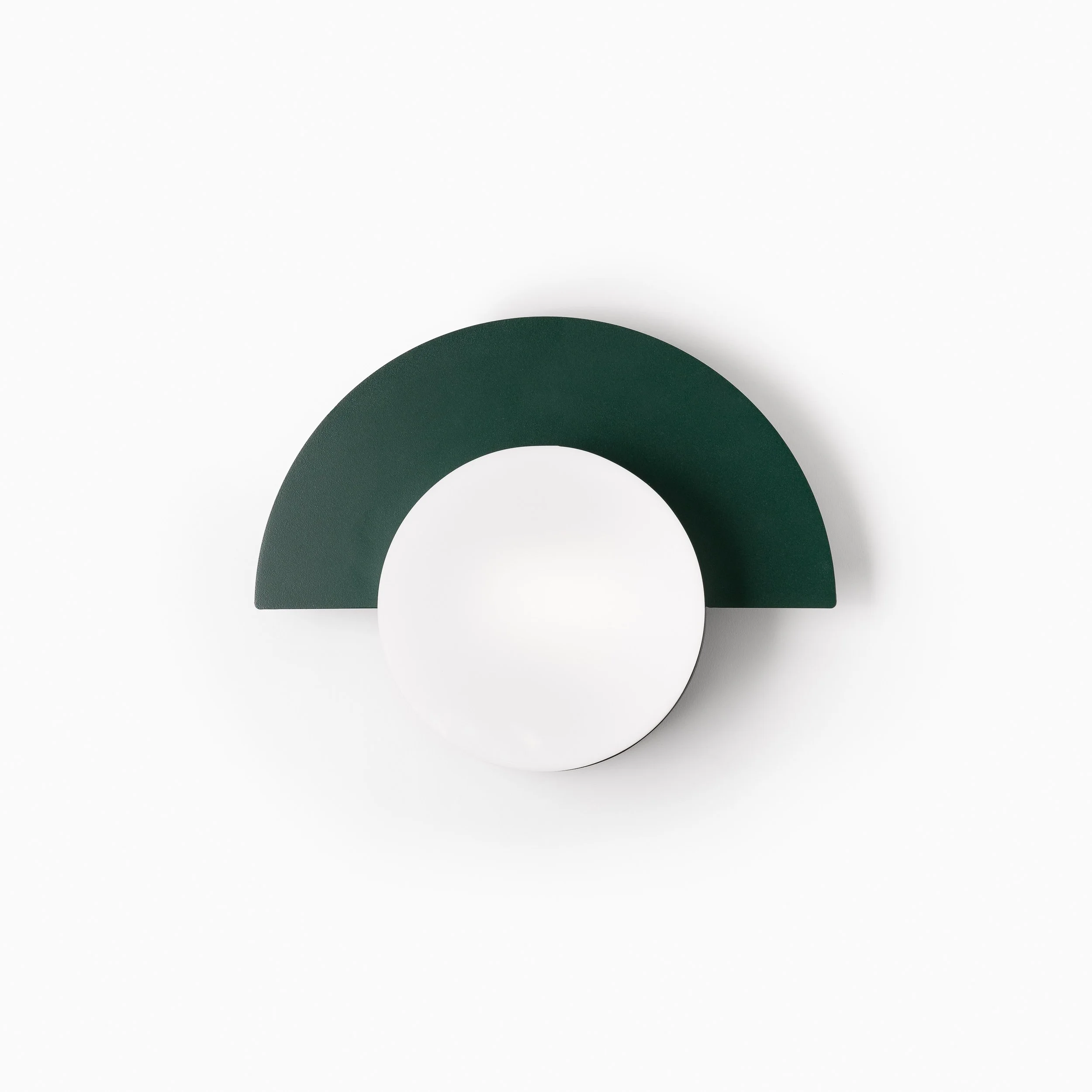A dark green semicircular object positioned on a white surface with a slight shadow, with its flat edge facing downward.