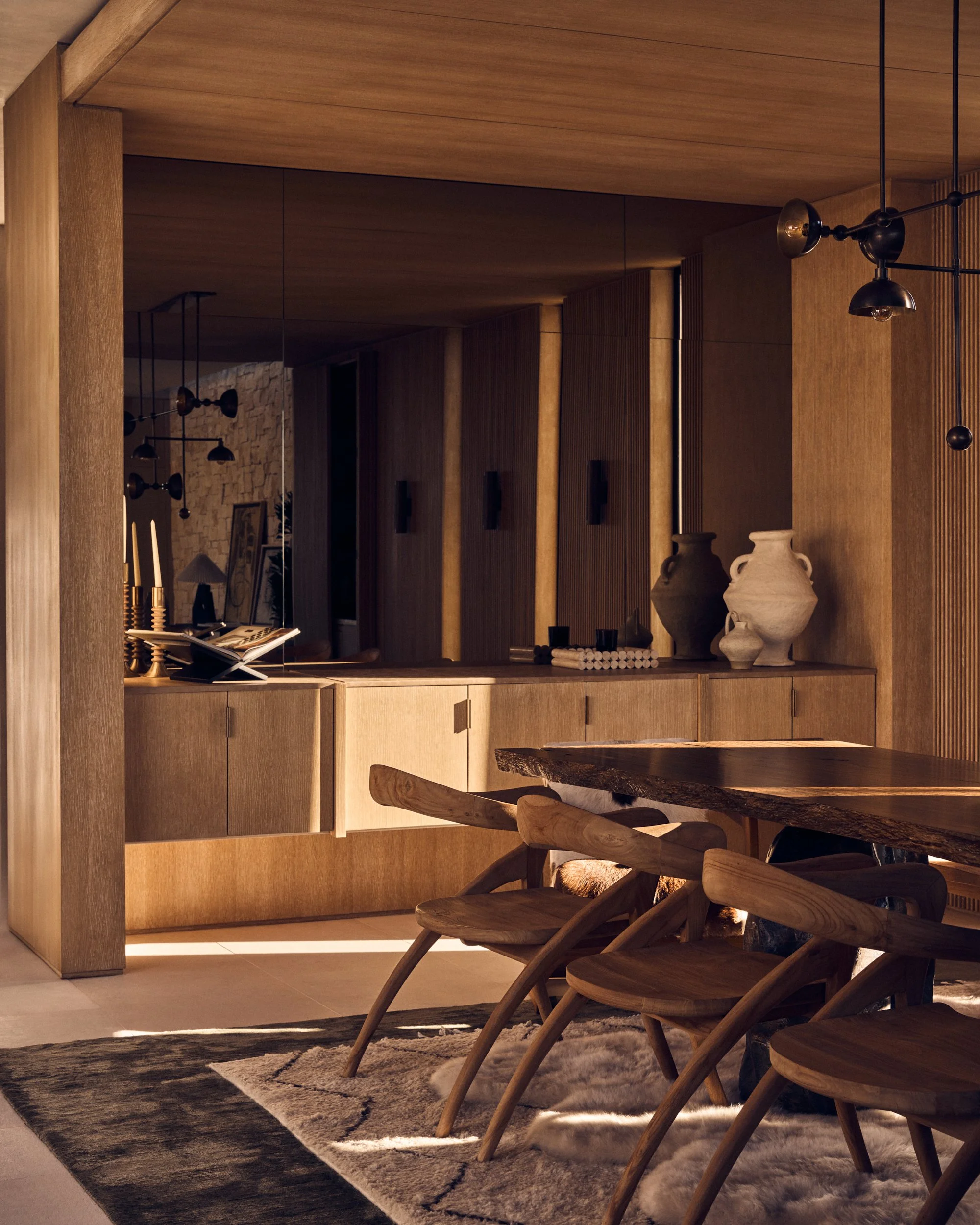Interior view of a room with wooden walls, a built-in wooden cabinet, decorative vases, and a dining table with chairs. The space is cozy and modern with warm lighting.