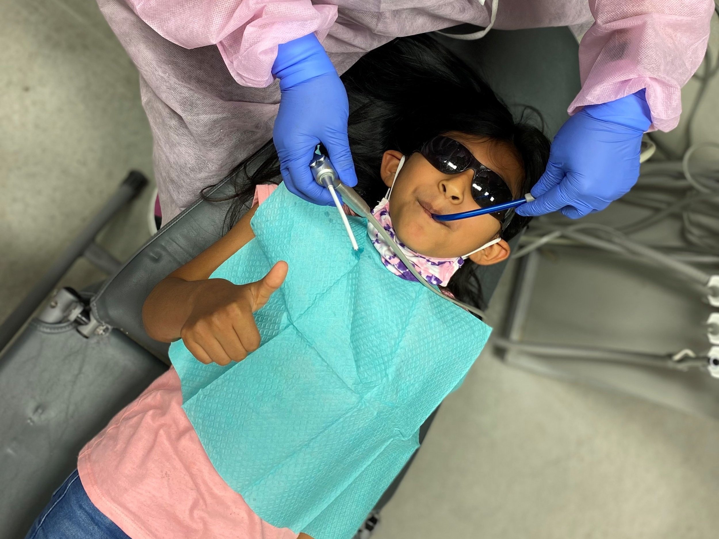 Una niña a la que le limpian los dientes en el dentista