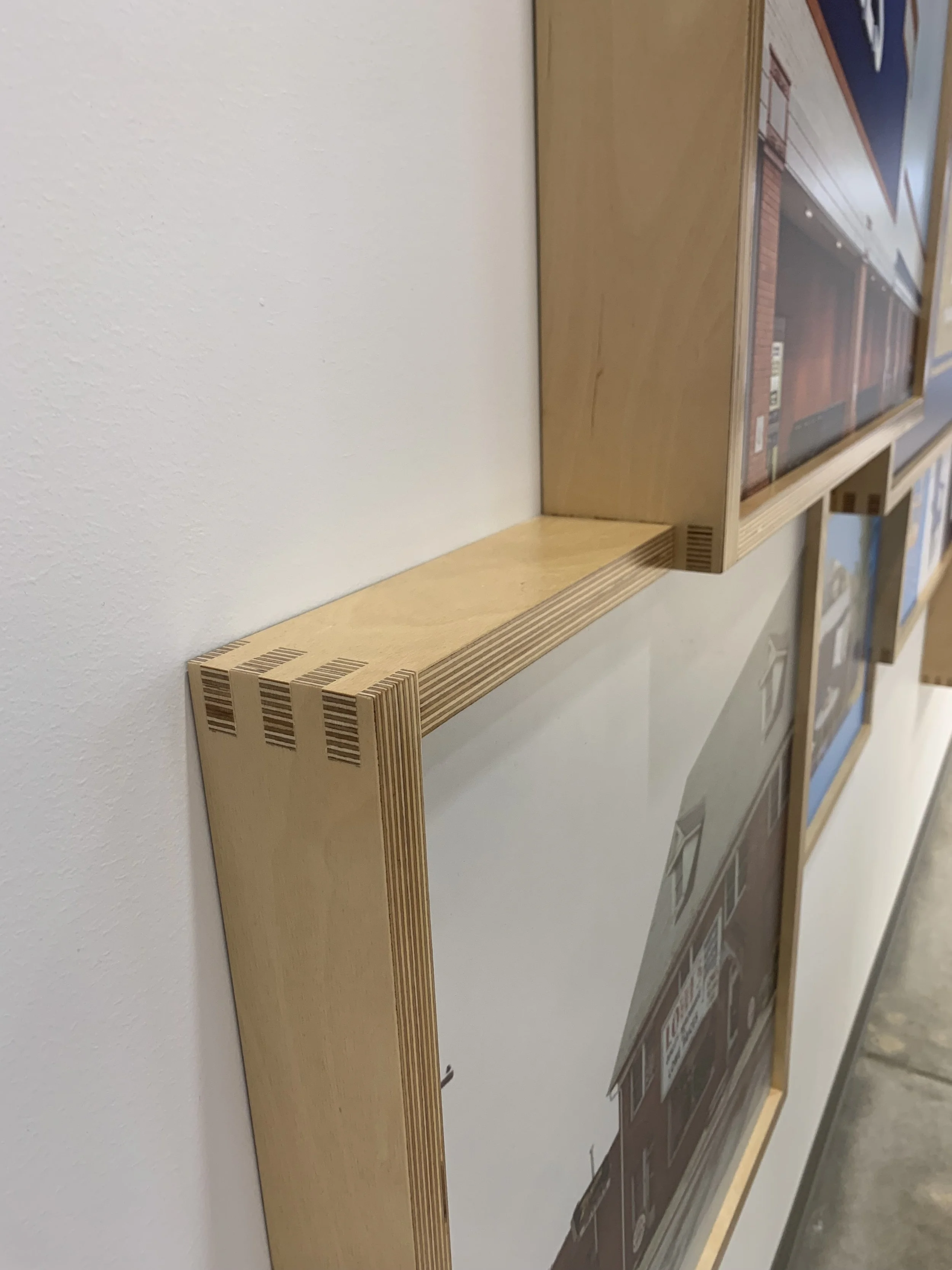 Close-up of wooden picture frames mounted on a wall.