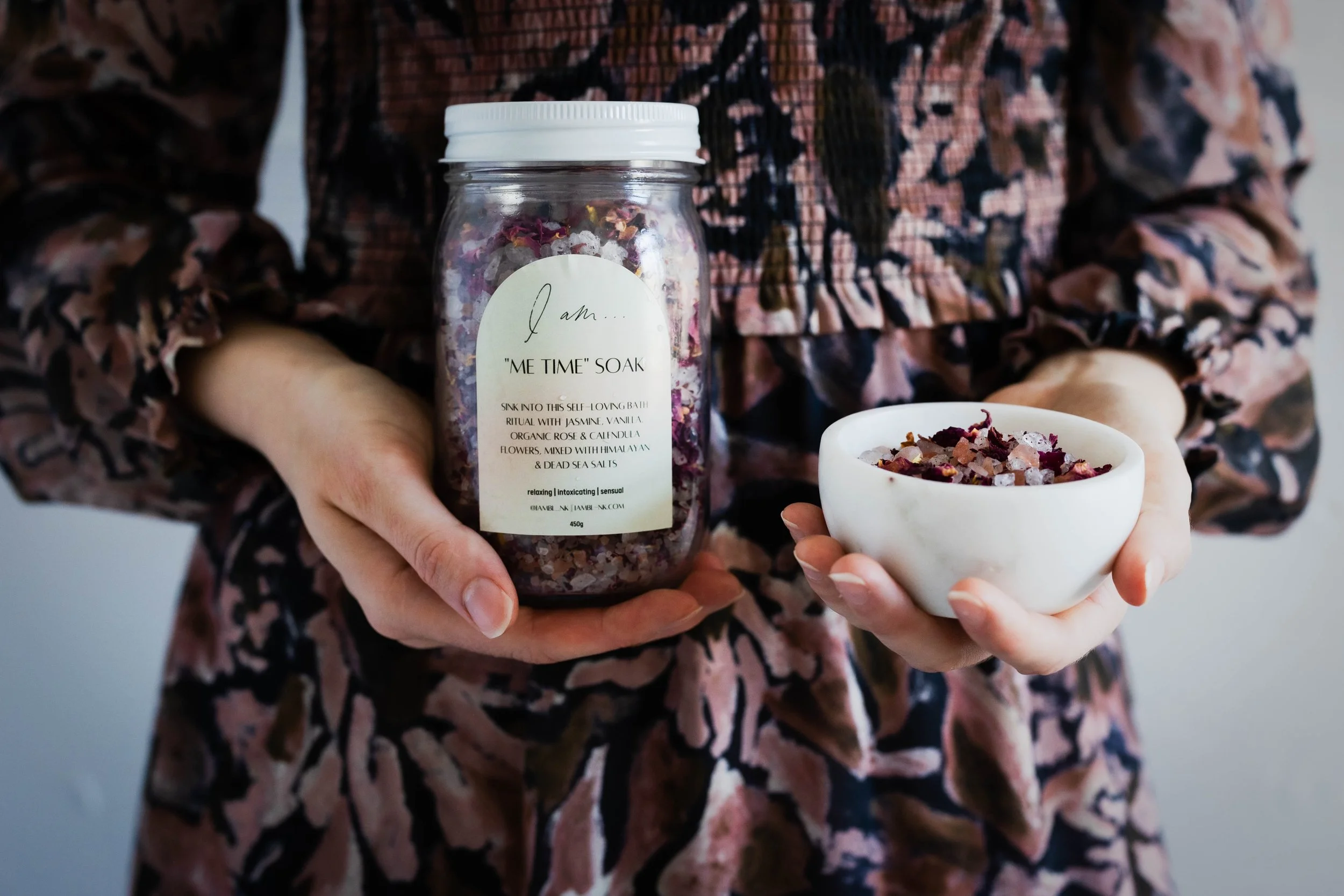 image of bath salt soaks in hands of girl wearing floral dress