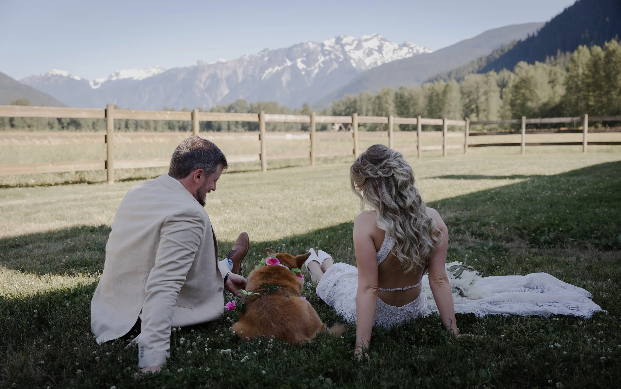 bride and groom with dog and mountain background portrait