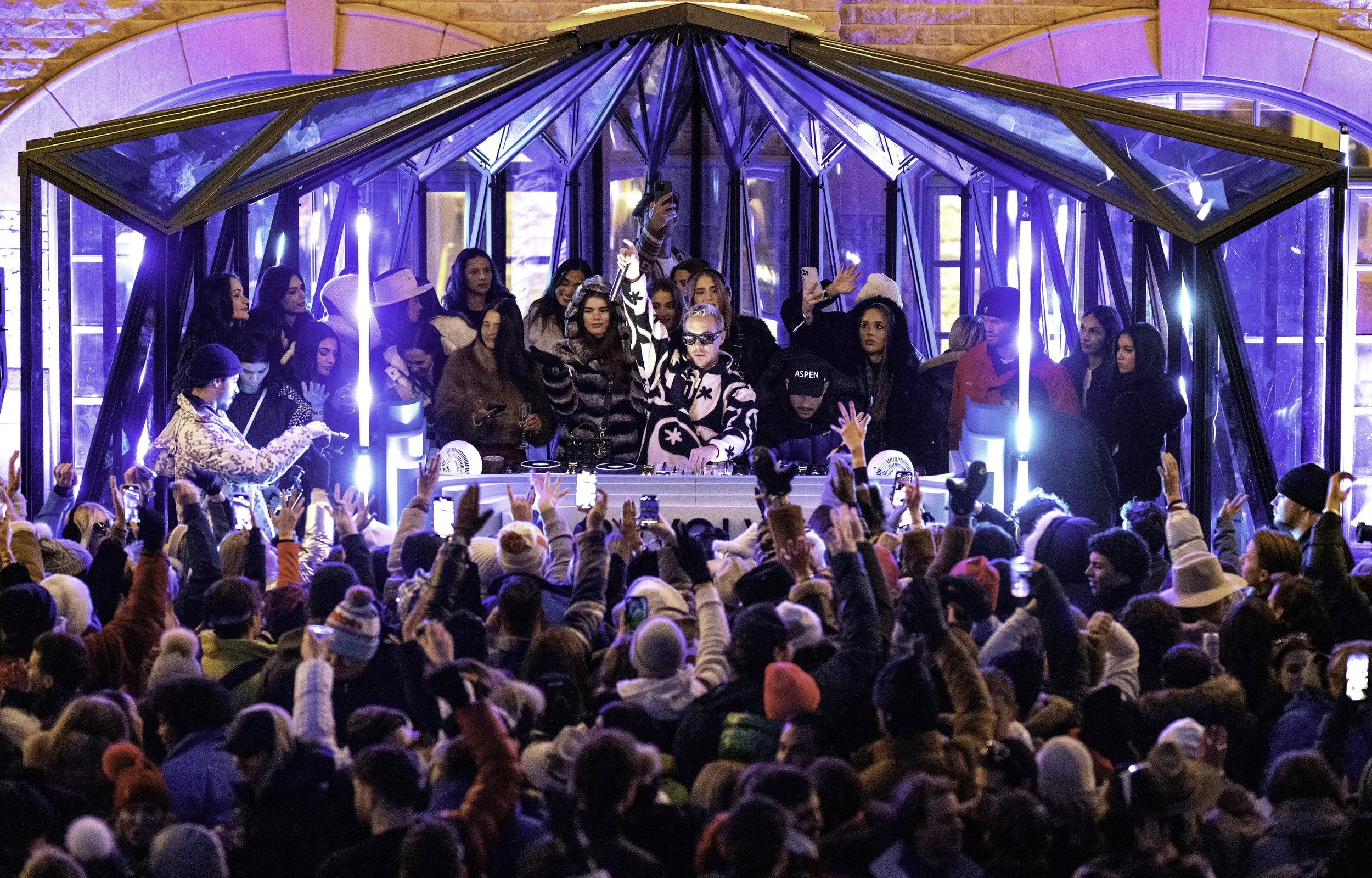 A crowd surrounding the DJ booth inside The Snow Lodge music pavilion