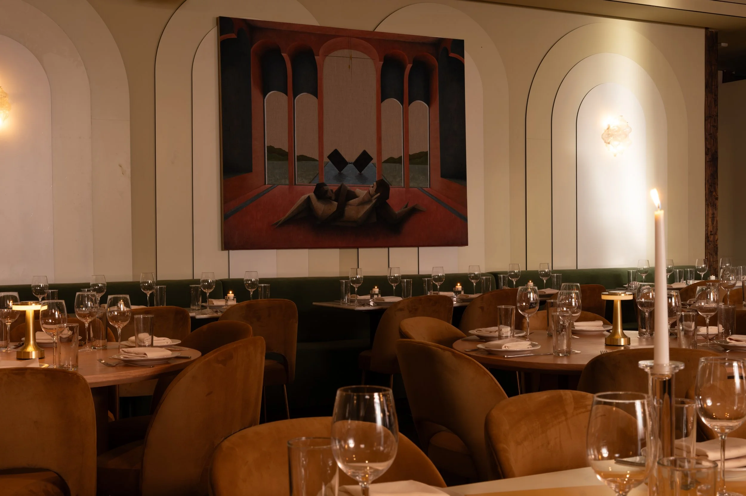 Candlelit dining tables beneath colorful geometric artwork at The Snow Lodge