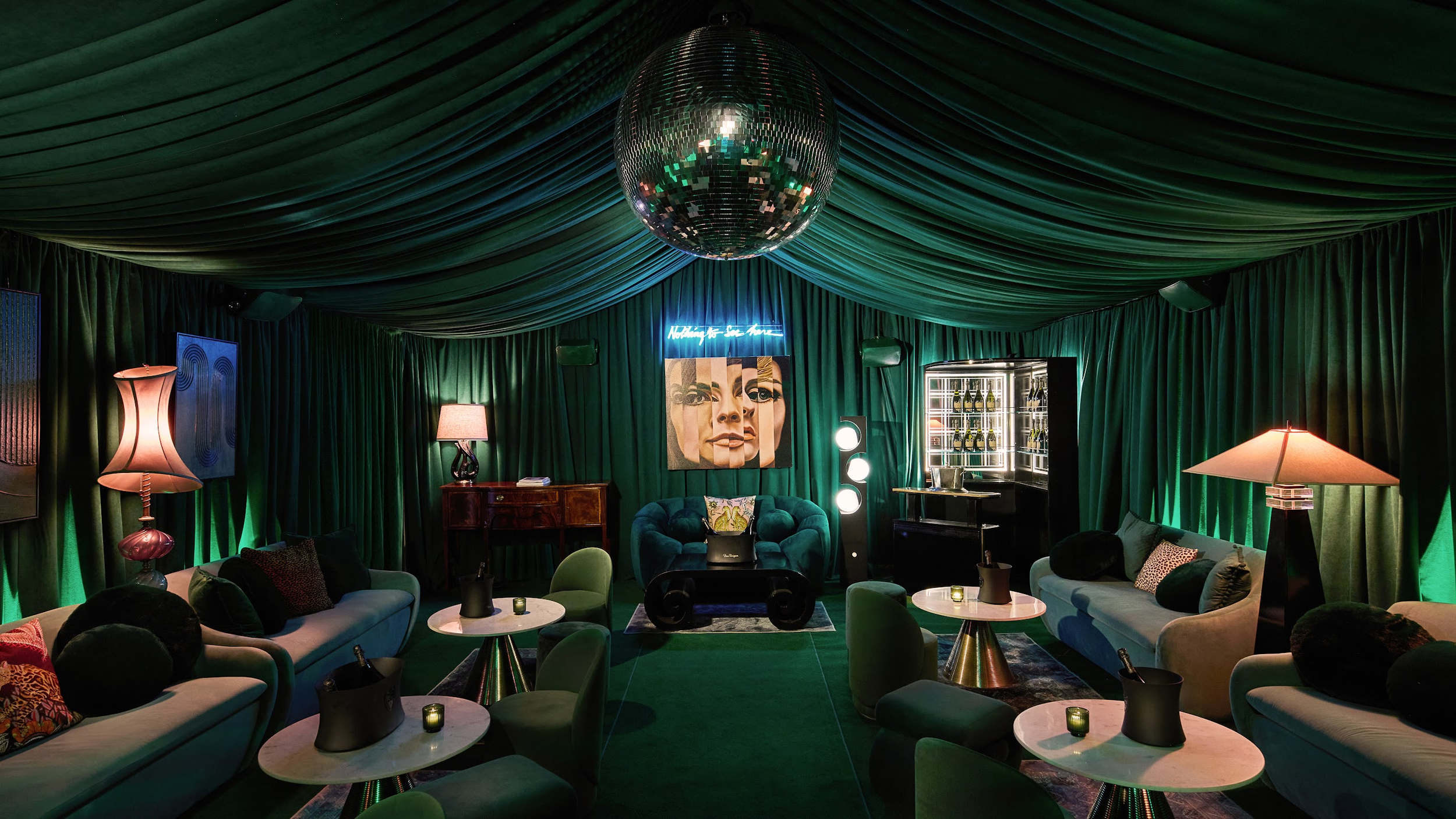 A lounge beneath emerald drapery and a mirrored disco ball in The Jade Room