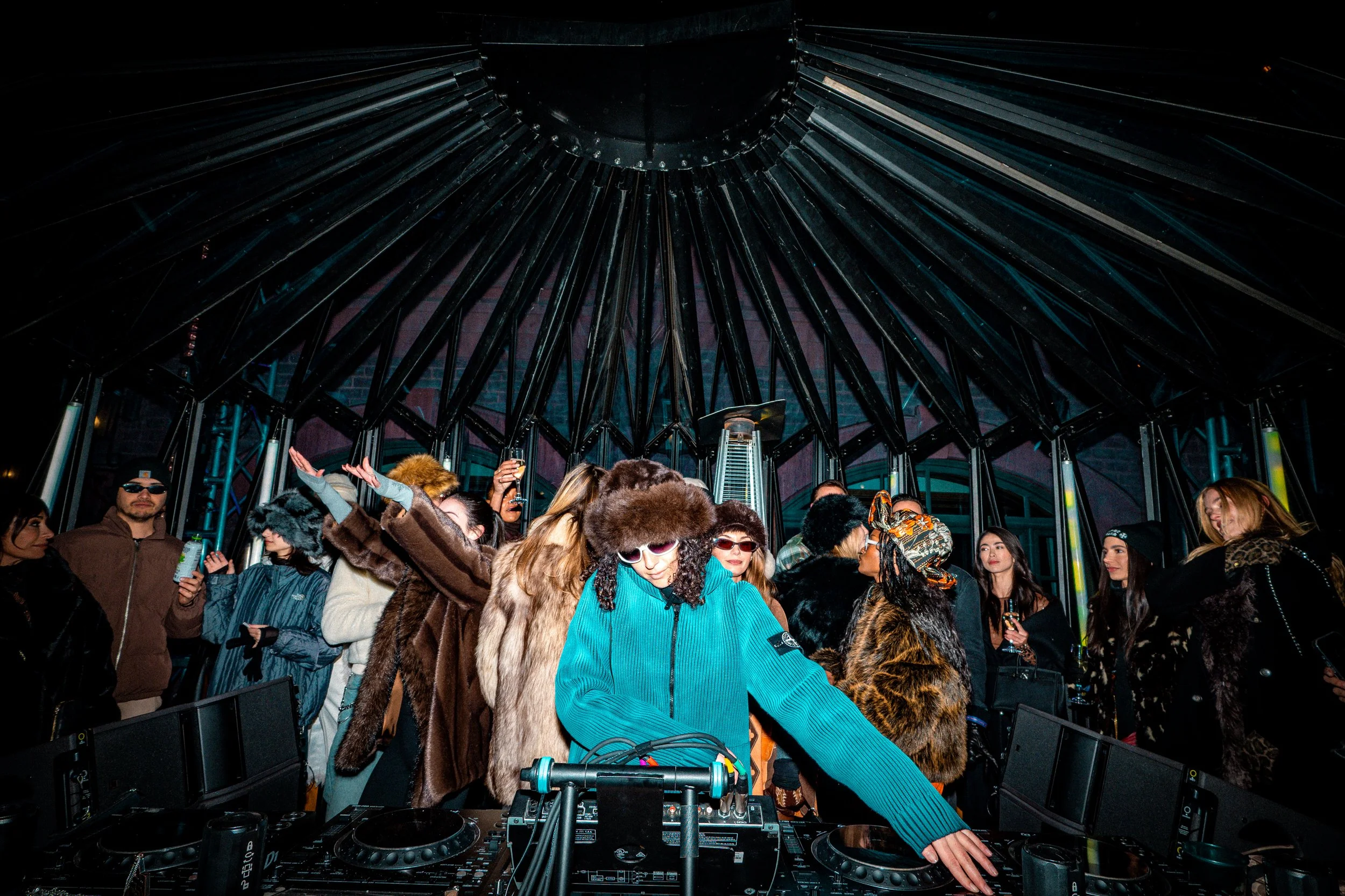 A DJ and guests inside The Snow Lodge pavilion