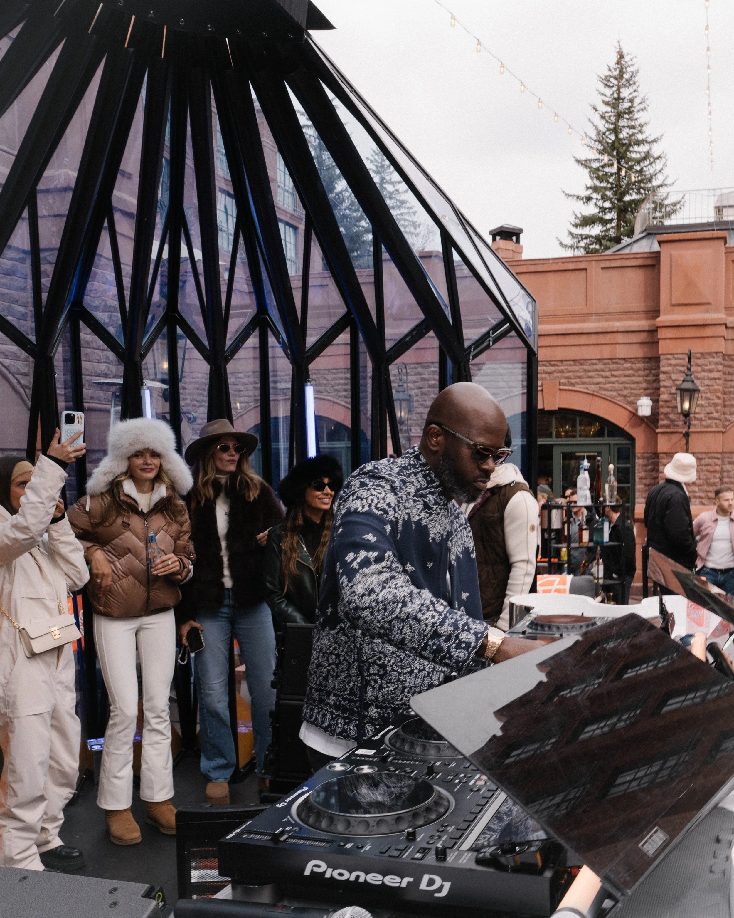 A DJ performing beside The Snow Lodge pavilion