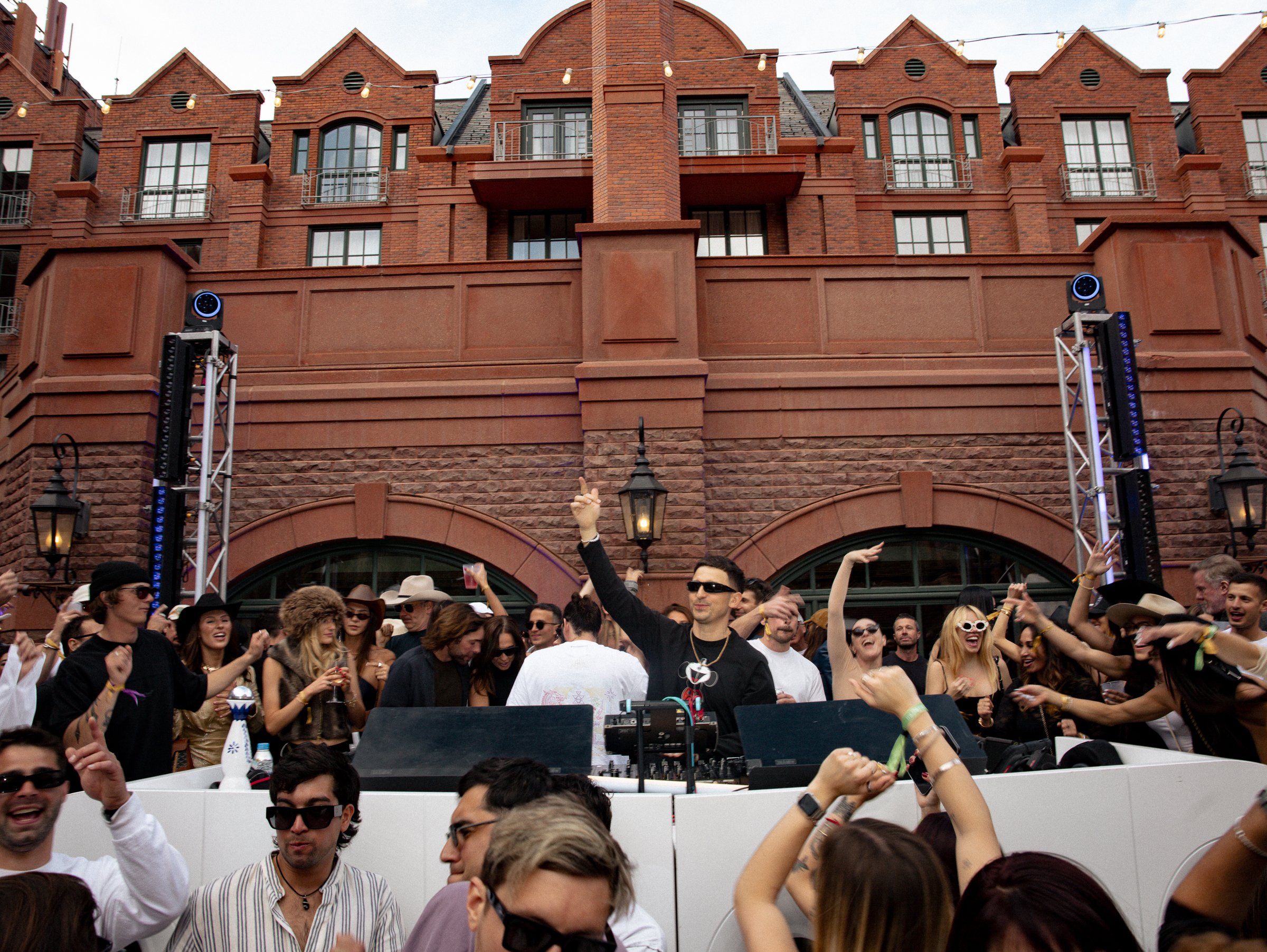 An outdoor DJ set and crowd in The Snow Lodge courtyard