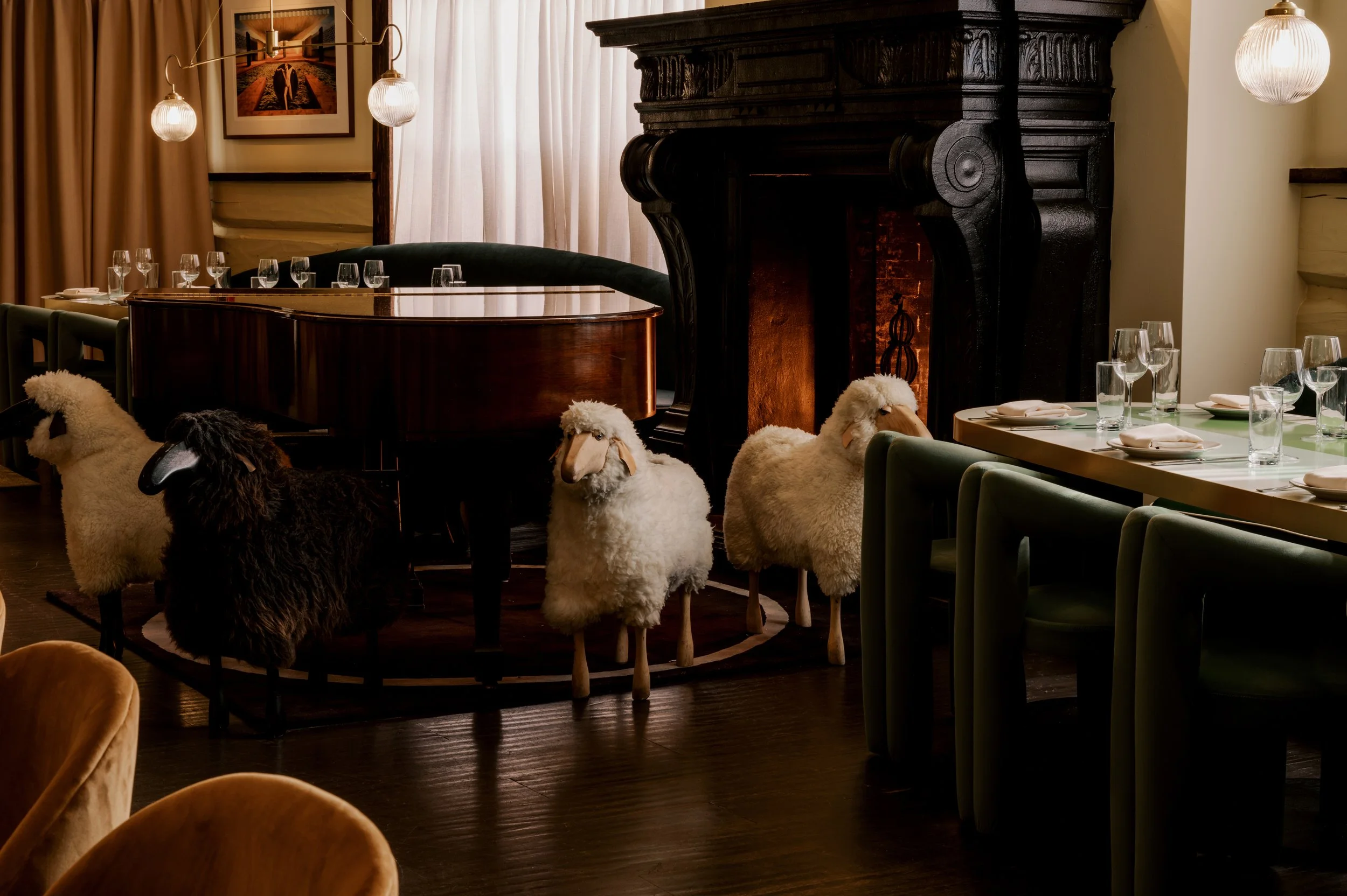 Decorative sheep figures gathered near the fireplace and bar inside The Snow Lodge